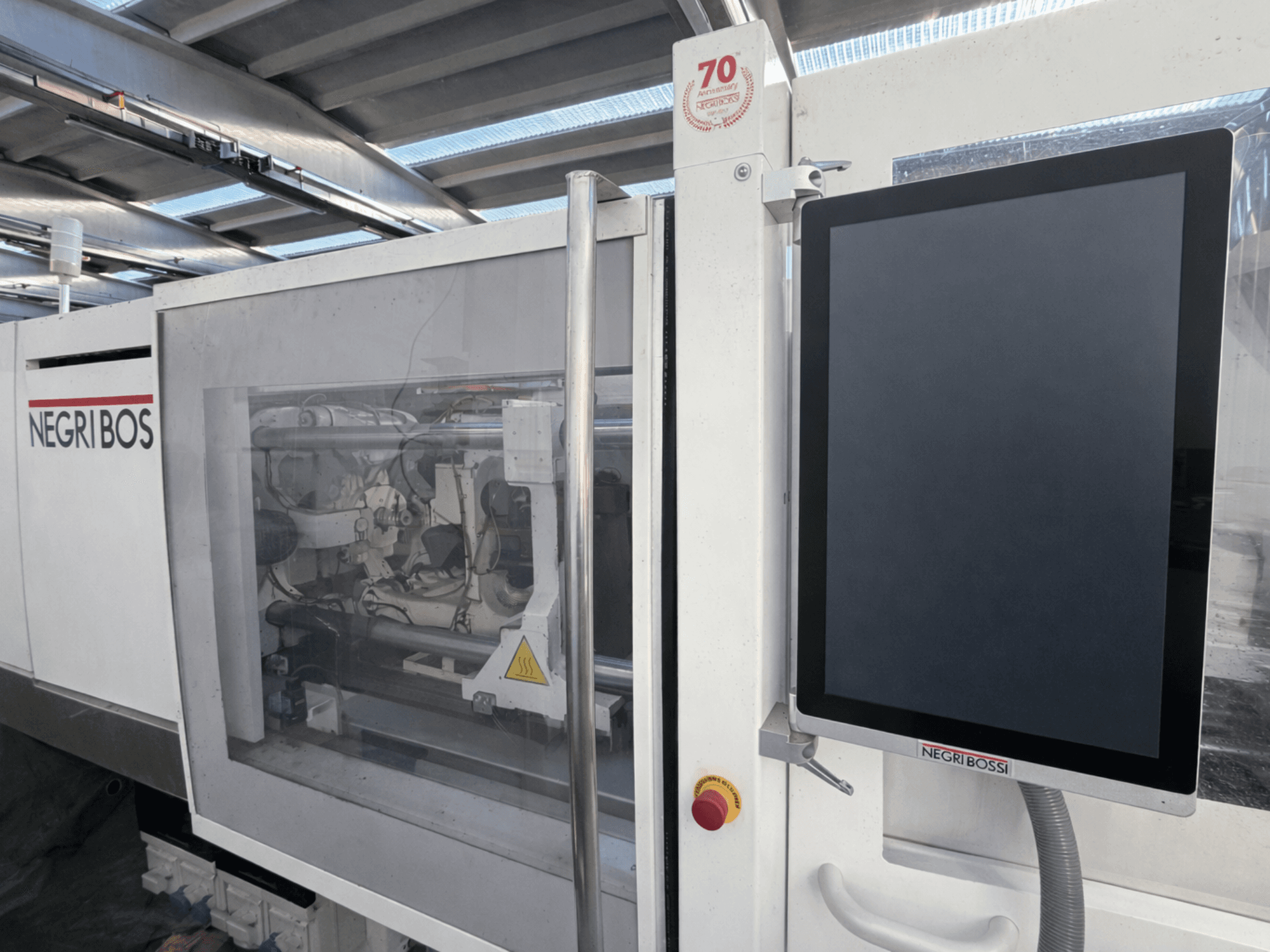 Máquina de moldagem por injeção eléctrica Negri Bossi ELE 80, vista frontal com ecrã de controlo e componentes internos visíveis.