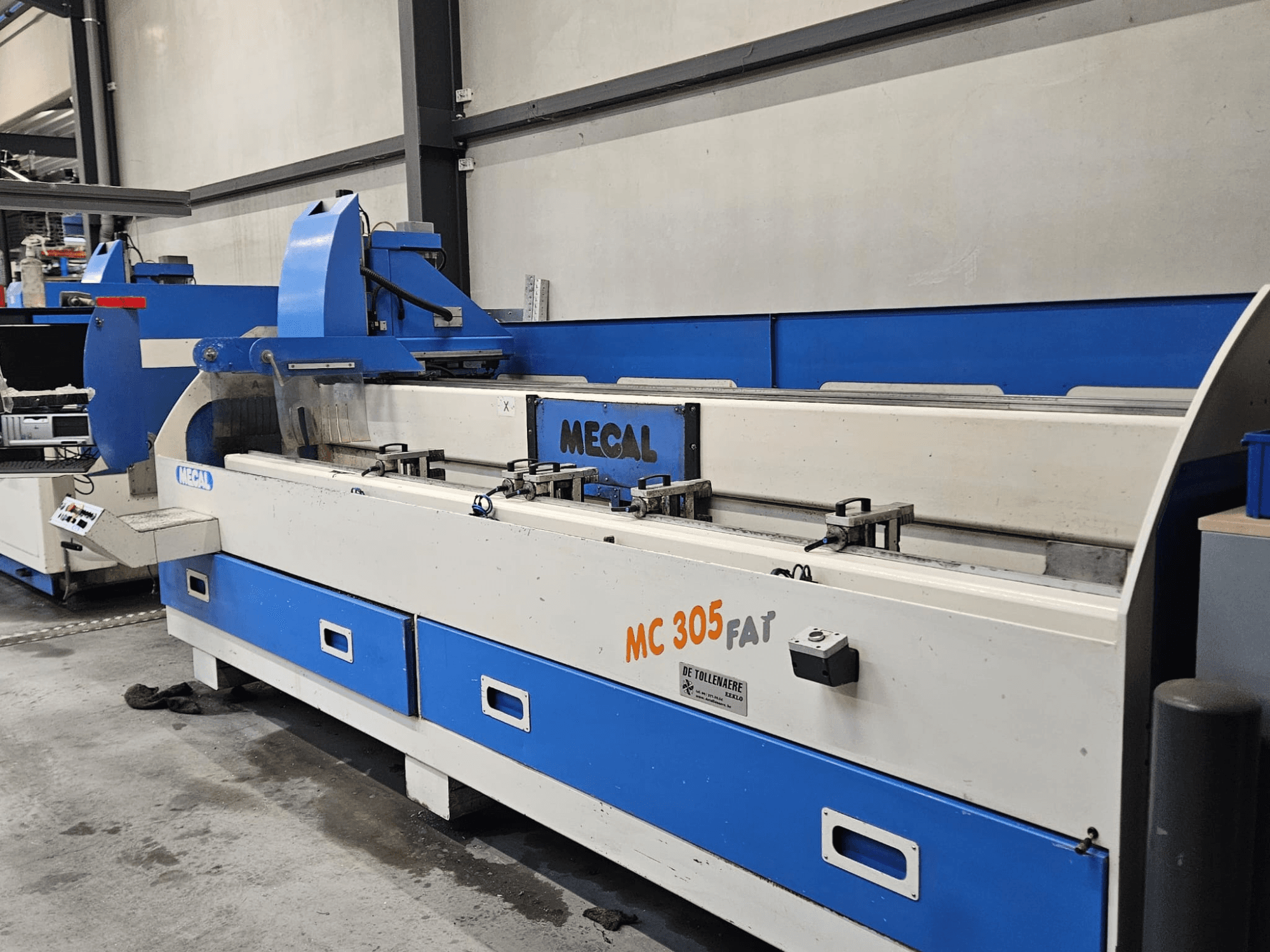 Máquina MECAL MC 305 FAT em fábrica, vista frontal mostrando os controlos e o design azul e branco.
