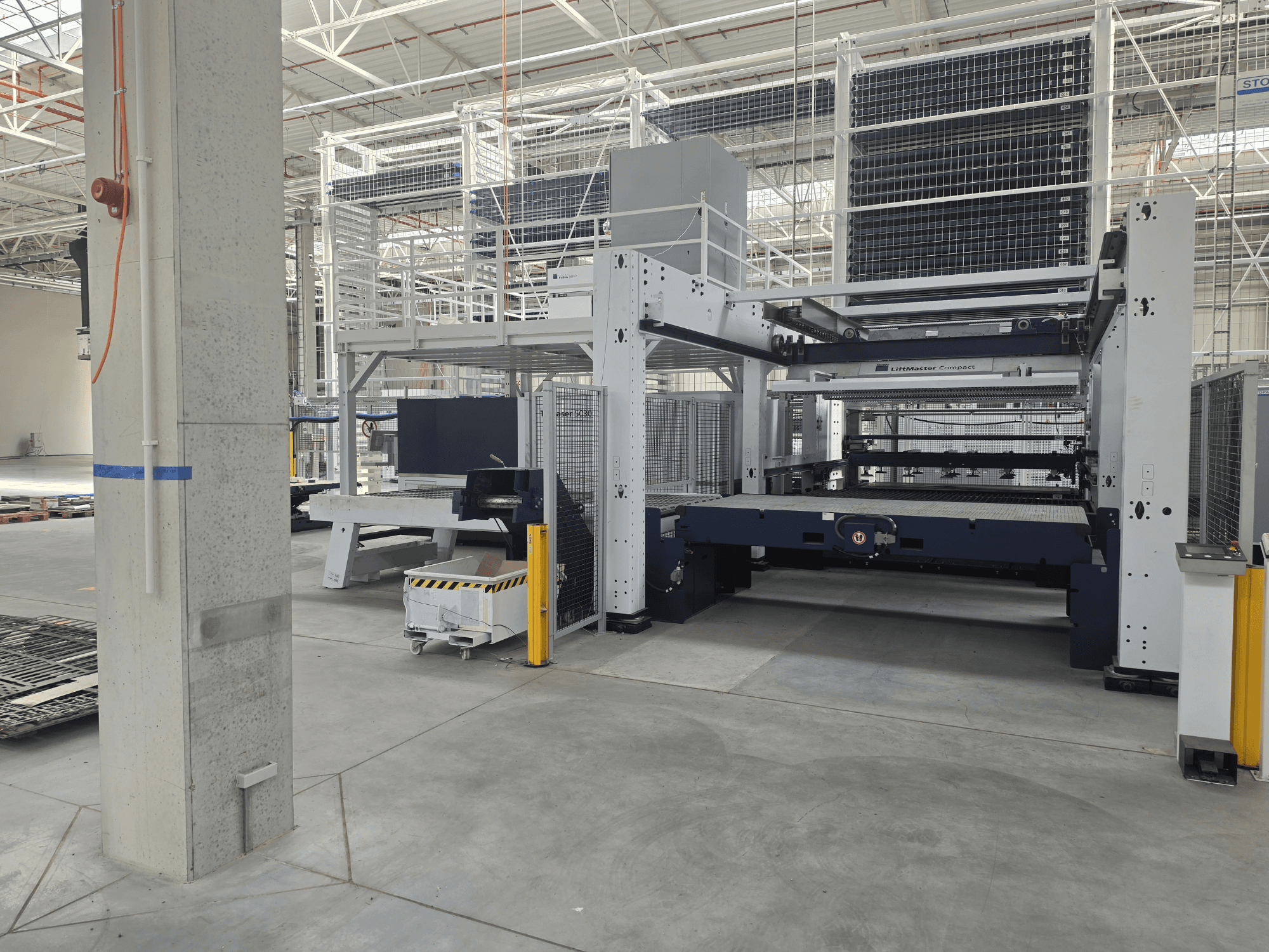 Vista frontal da TRUMPF TruLaser 5030 fiber L76 FMC, mostrando a máquina de corte a laser de fibra num ambiente industrial espaçoso.