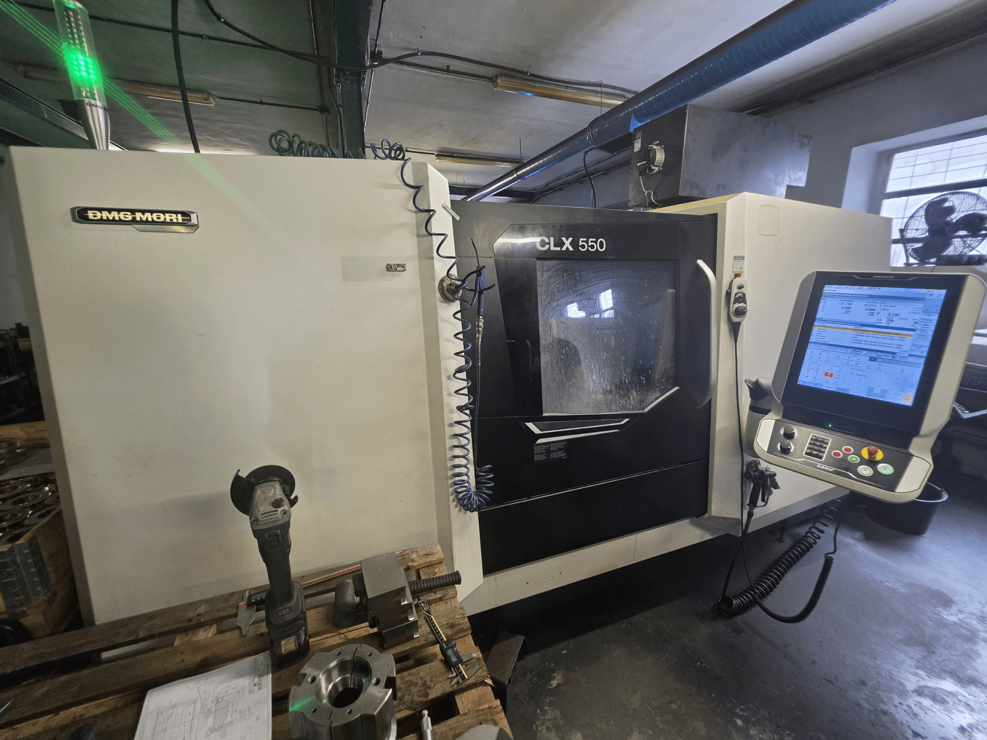 Torno horizontal DMG MORI CLX 550 V3, vista frontal que mostra o painel de controlo, as ferramentas de corte e a estrutura da máquina.