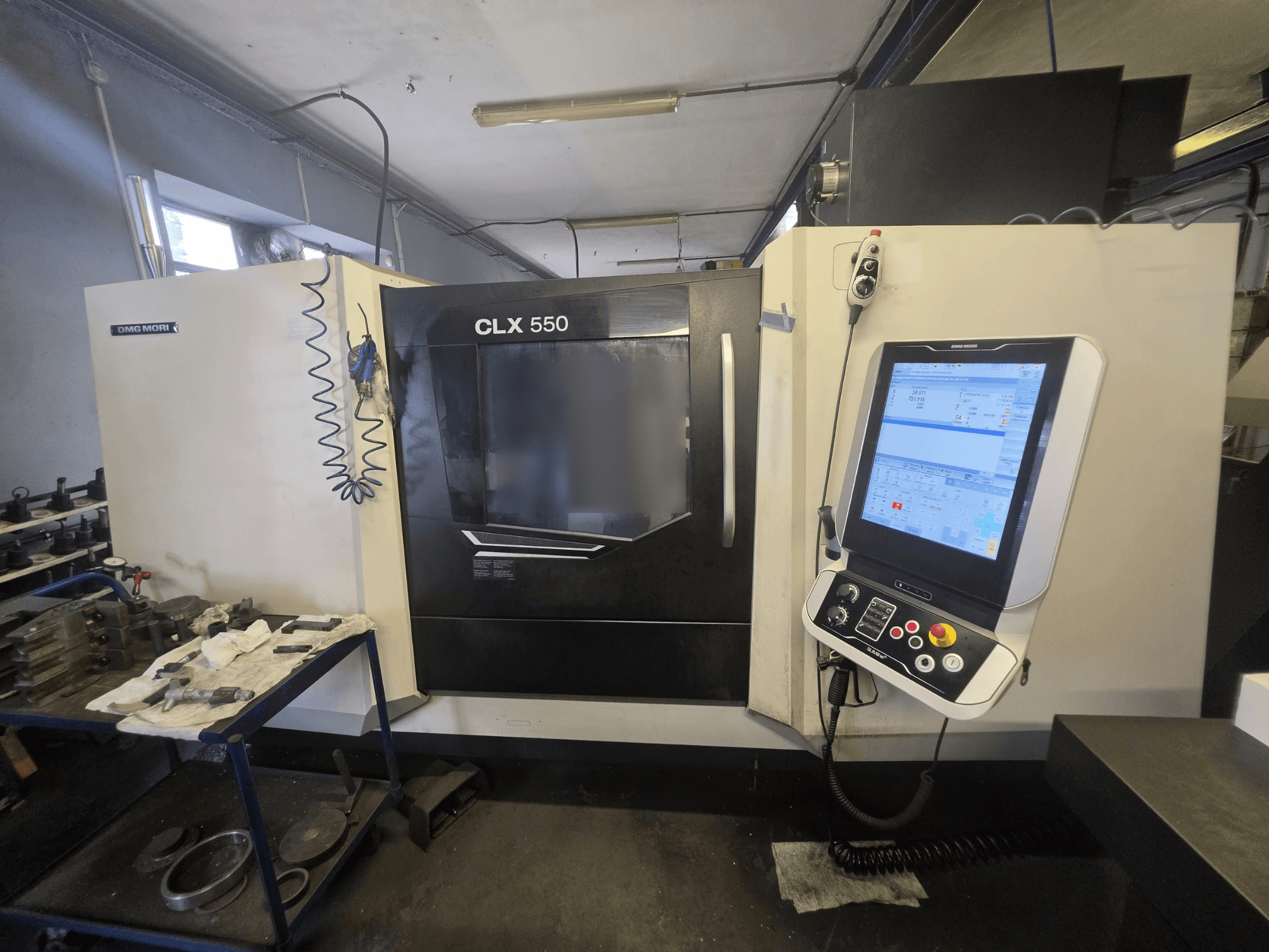 Torno horizontal DMG MORI CLX 550 V3, vista frontal, mostrando o painel de controlo e a área de trabalho com as ferramentas.