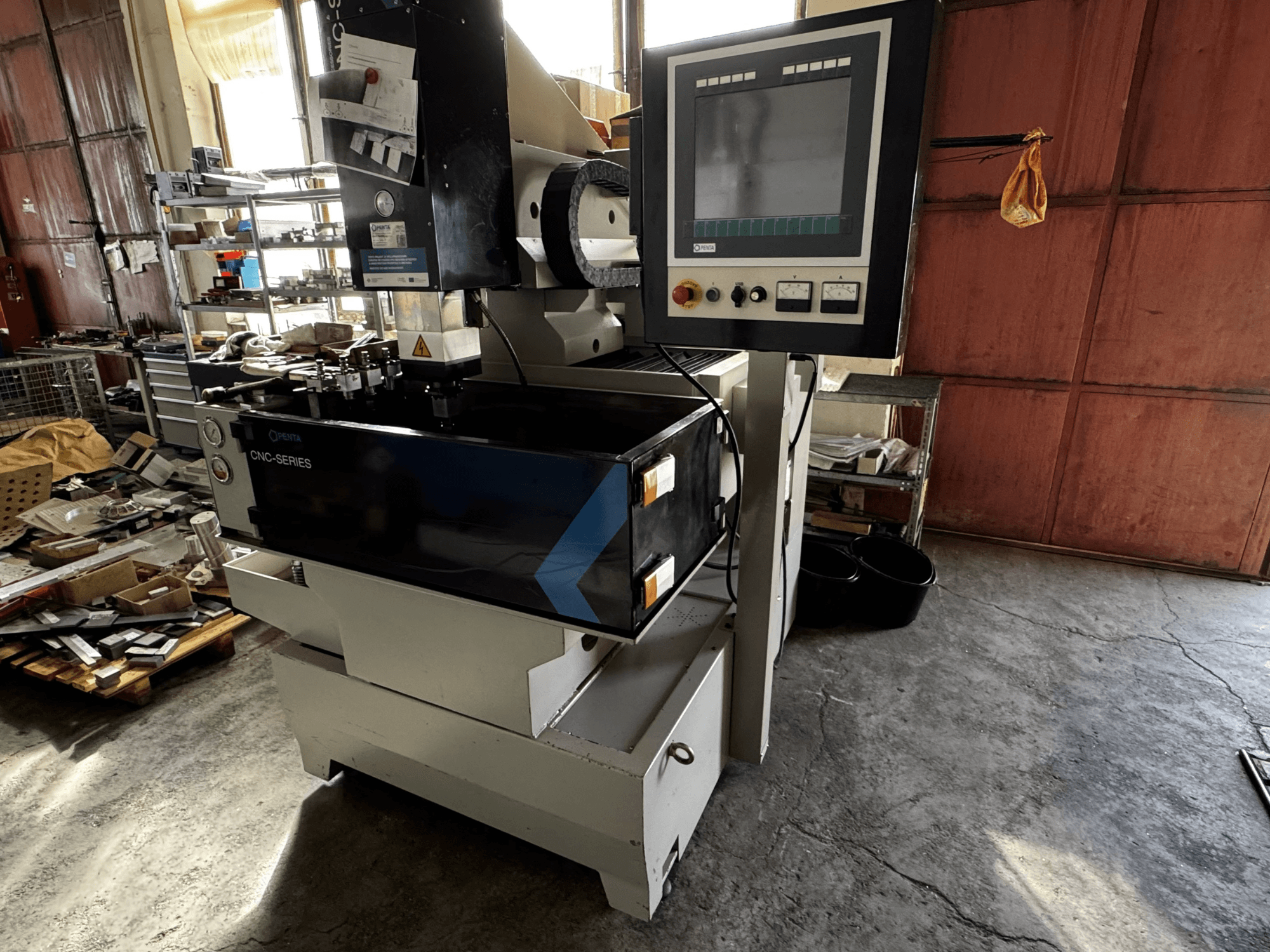 Máquina de electroerosão por penetração CNC PENTA 433GS, vista frontal. Apresenta painel de controlo, suporte de eléctrodos e mesa de trabalho metálica.