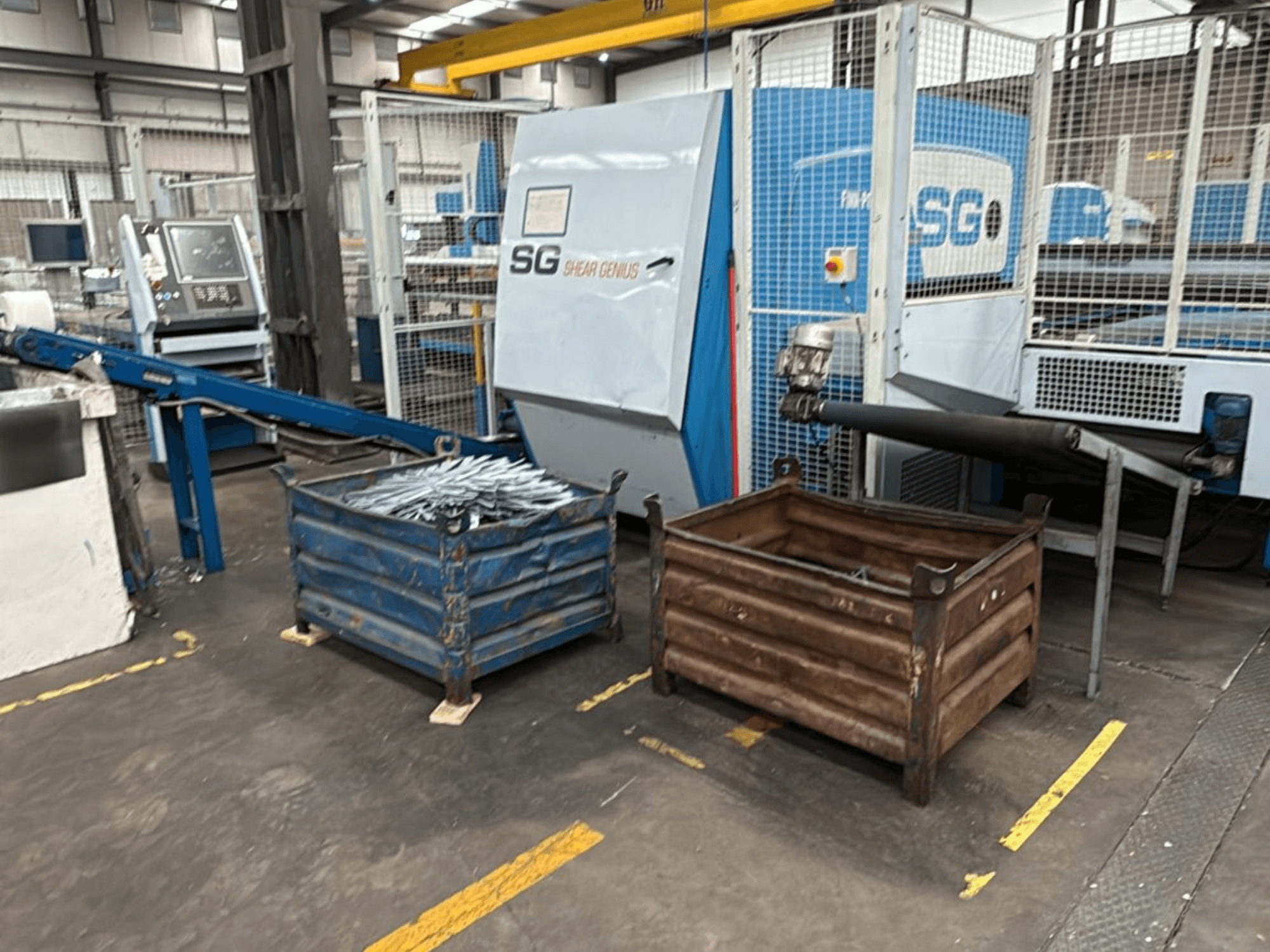 Máquina de perfuração e dobragem Finn-Power SG6 12.61, vista frontal com contentores de metal ao lado, numa oficina.