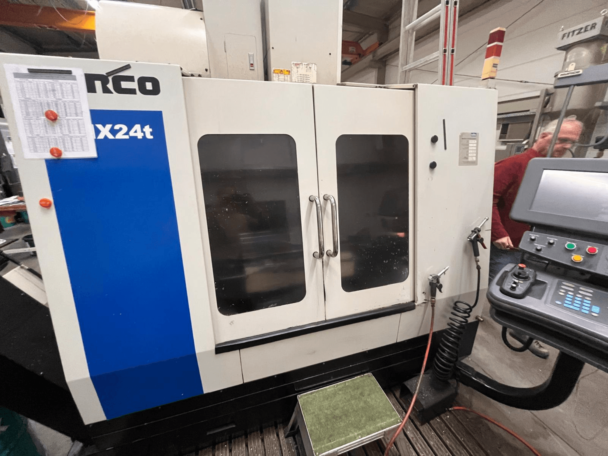 Centro de maquinação vertical da Hurco, modelo VX24t, mostrado de frente com painel de controlo e portas transparentes.