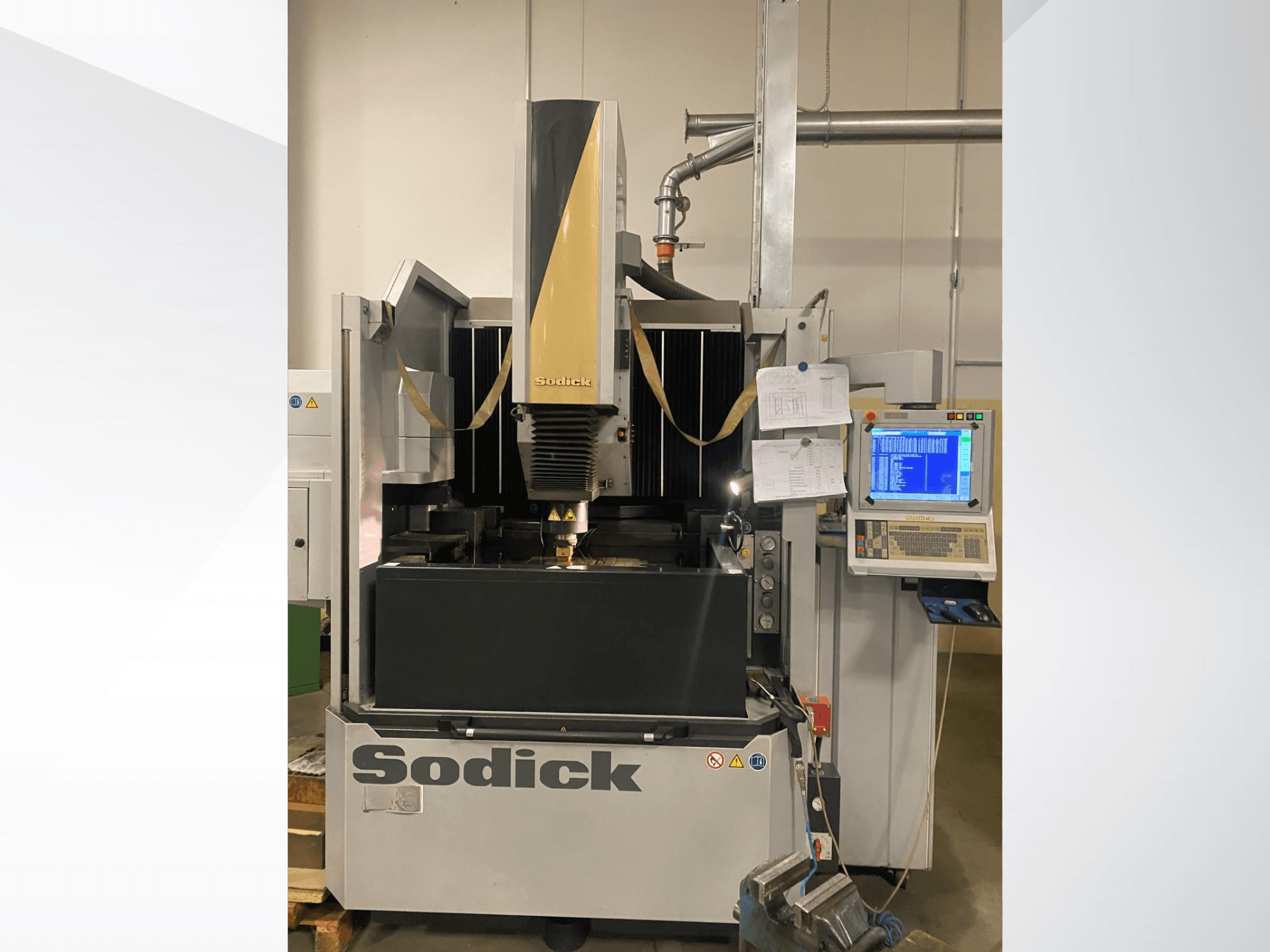 Máquina EDM Sodick em vista frontal, com um painel de controlo, mesa de trabalho e uma cabeça de corte suspensa.