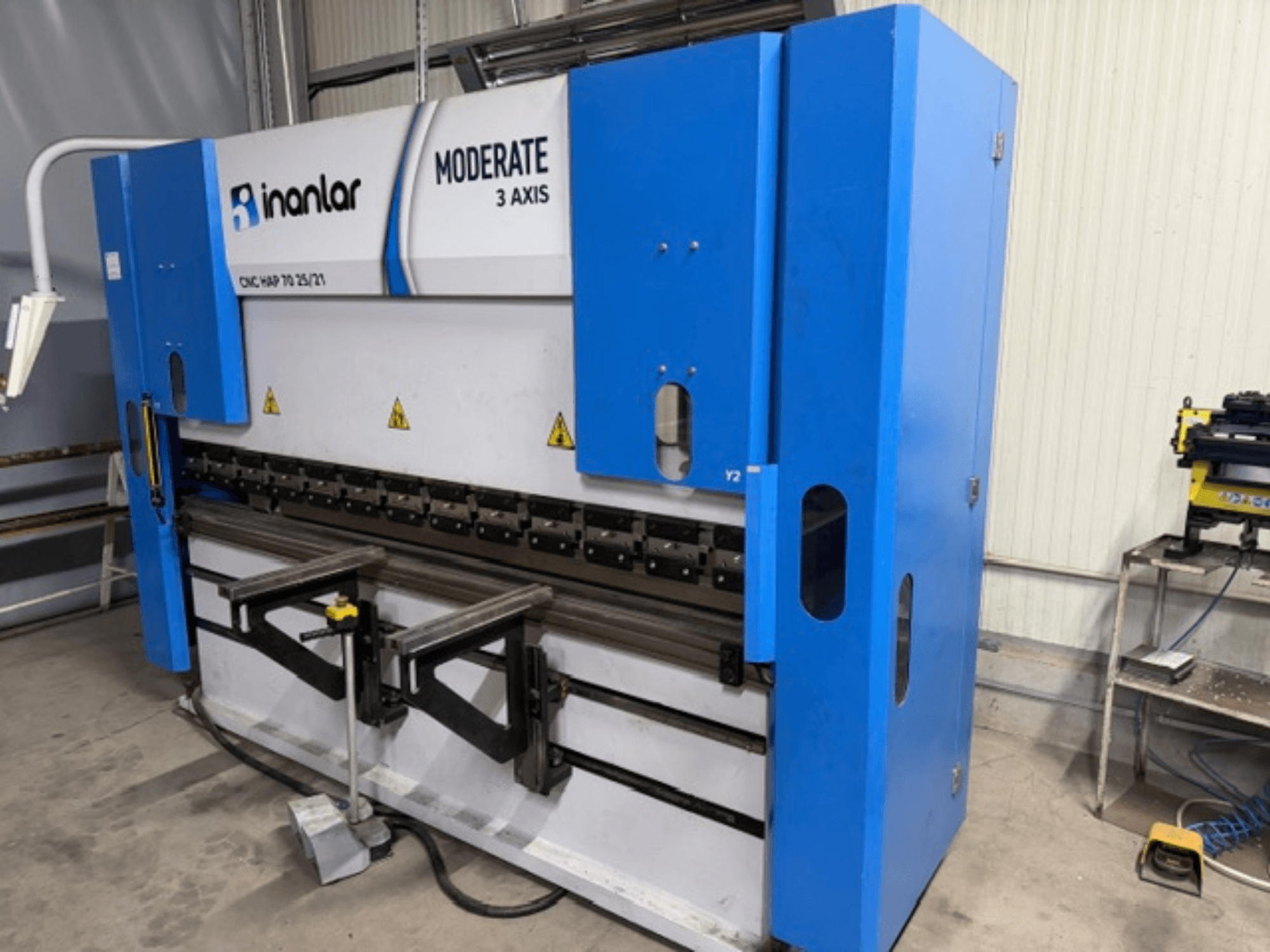 Máquina CNC de 3 eixos Inanlar Moderate em azul, vista frontal, com alavancas de controlo e etiquetas de segurança visíveis no corpo.