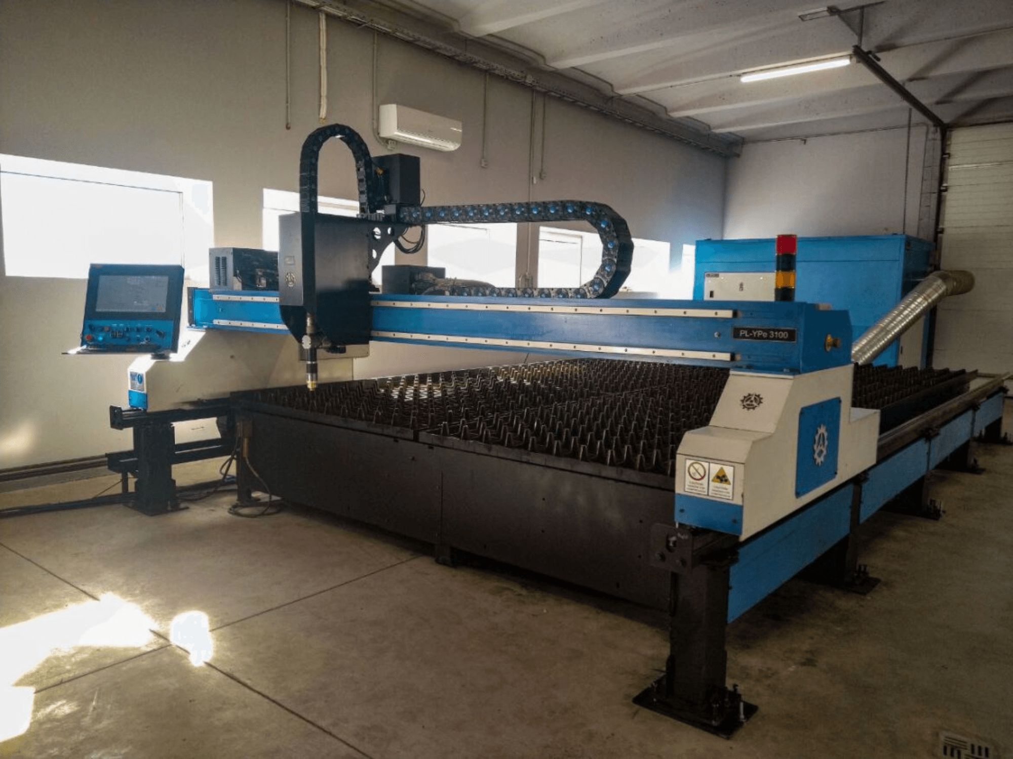 Máquina de corte CNC PL-YP© 3100 com ecrã, vista frontal, com uma base de corte de metal e um sistema preciso de orientação dos bicos.