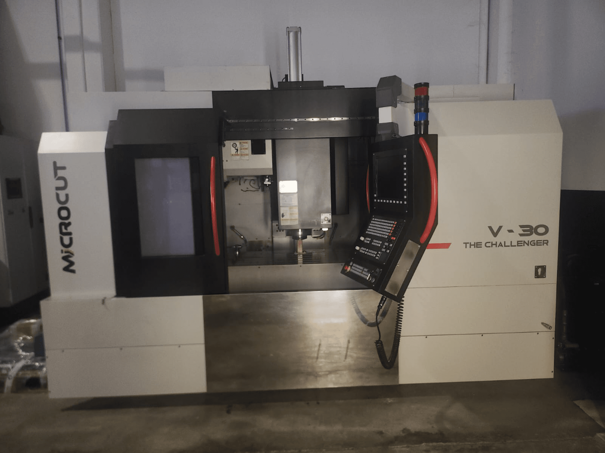 Microcut V-30 A máquina CNC Challenger, vista frontal, com painel de controlo, área de corte e elementos de design industrial.