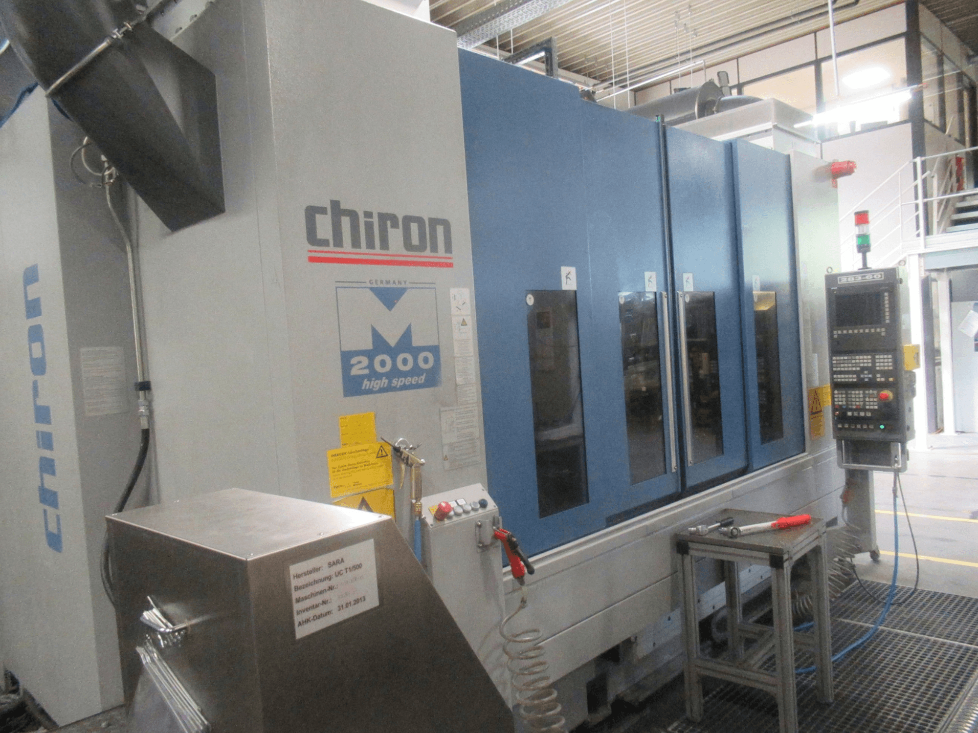 Centro de maquinagem vertical CHIRON Mill 2000, vista frontal com painel de controlo, design azul e funcionalidades de alta velocidade visíveis.