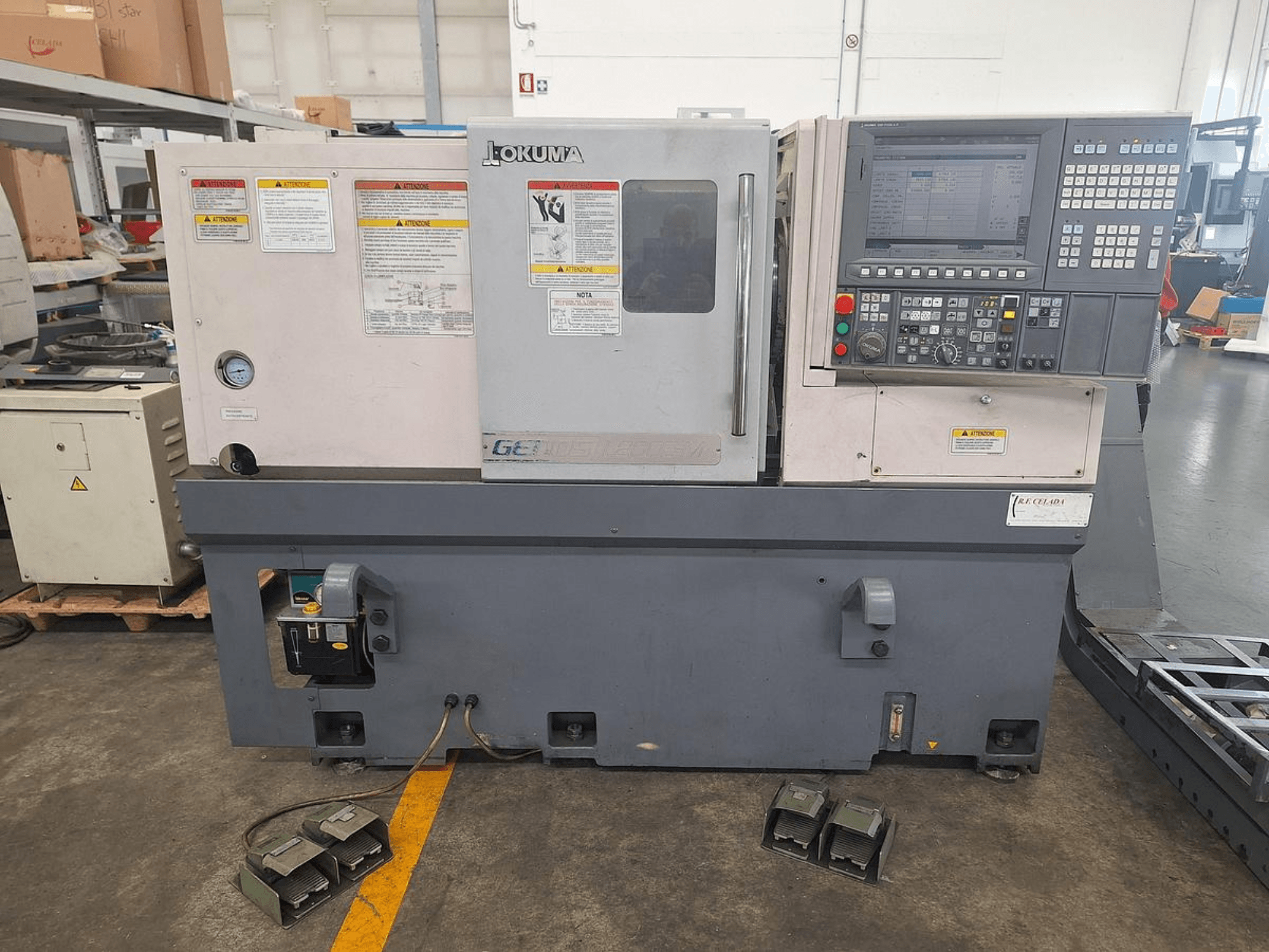 Okuma GENOS L200E-M torneiro horizontal em vista lateral; possui painel de controlo, avisos de segurança e pedais.