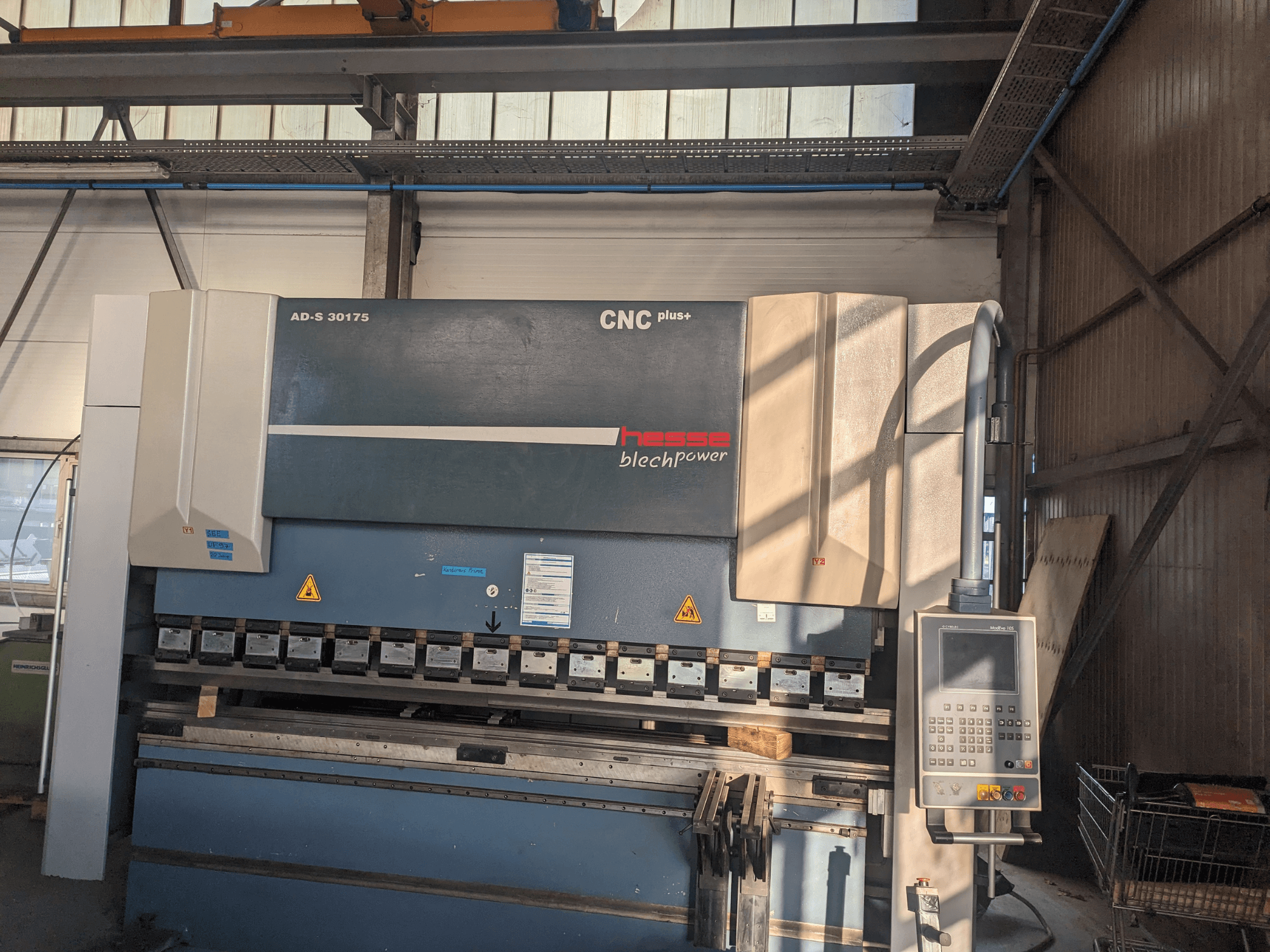 Máquina de dobragem CNC Hesse AD-S 30175, vista frontal, com painel de controlo e ferramentas, colocada num ambiente de oficina.