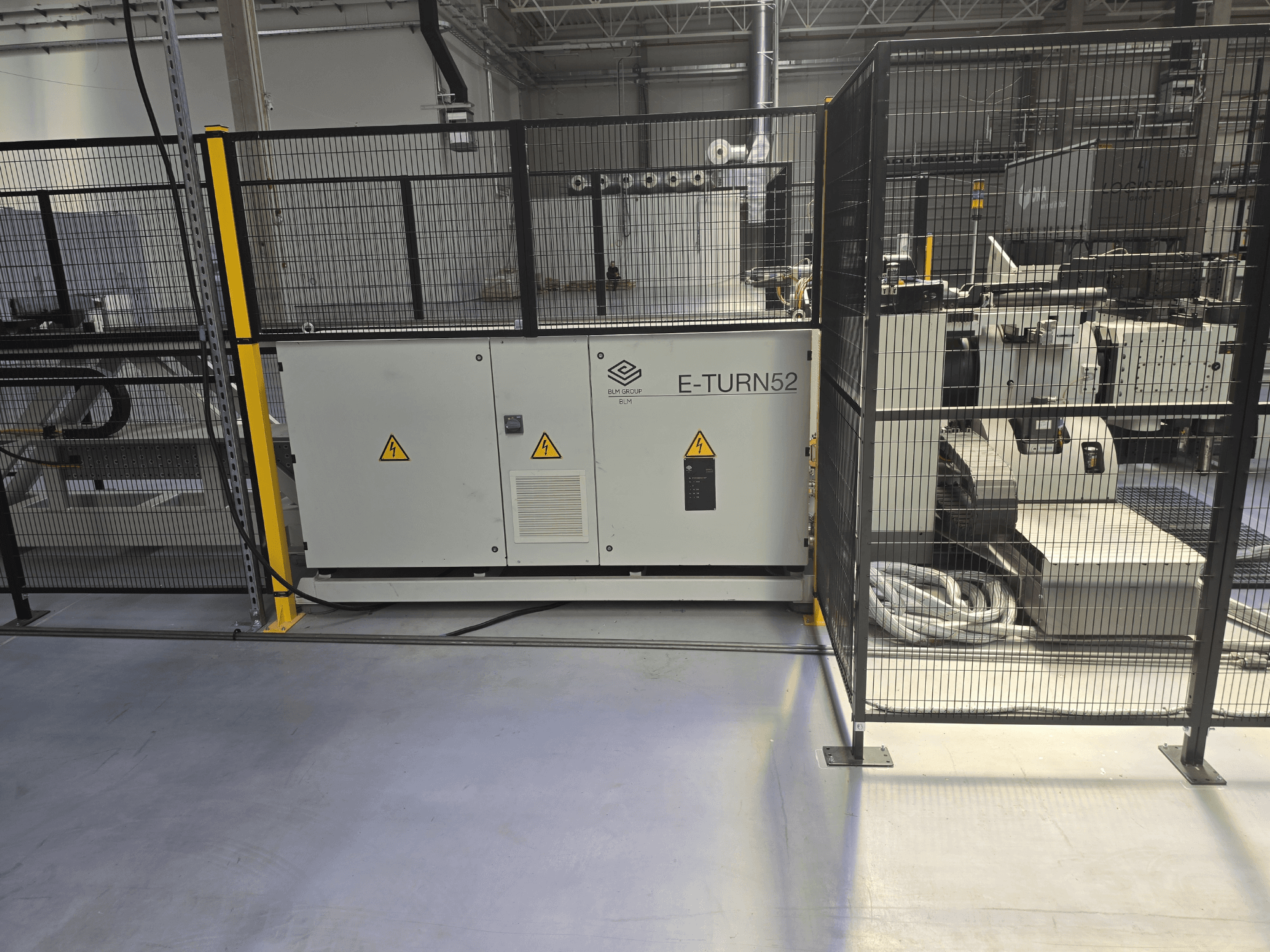 Máquina de dobragem por matriz BLM E-TURN 52B numa vista lateral, com proteções de segurança e comandos visíveis.