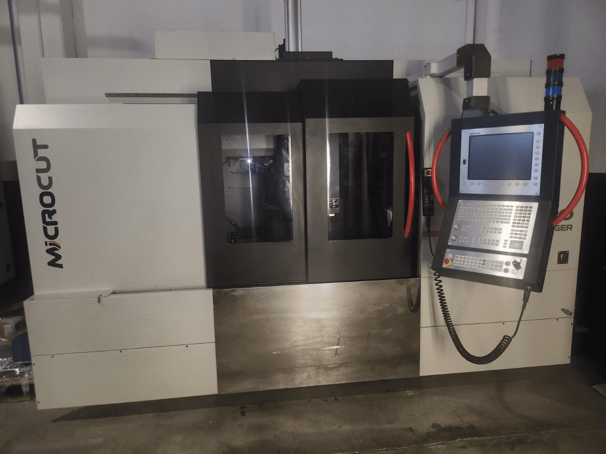 Máquina CNC Microcut vista de frente; apresenta painel de controlo, janelas duplas, design industrial e acabamento metálico.