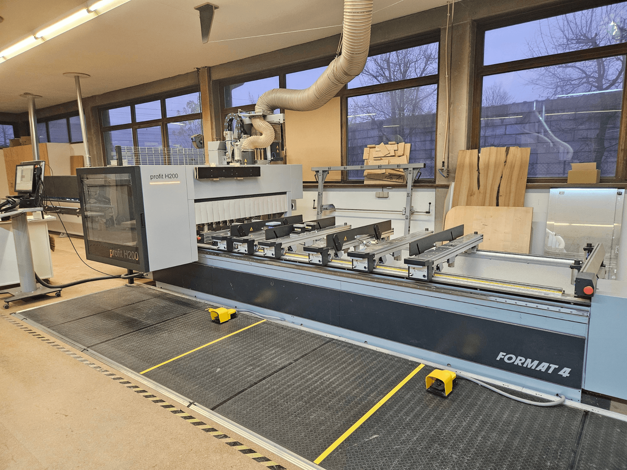 Máquina CNC H200 de formato 4 profit, vista frontal, com a mesa de corte, o painel de controlo e o sistema de extração de poeiras visíveis.