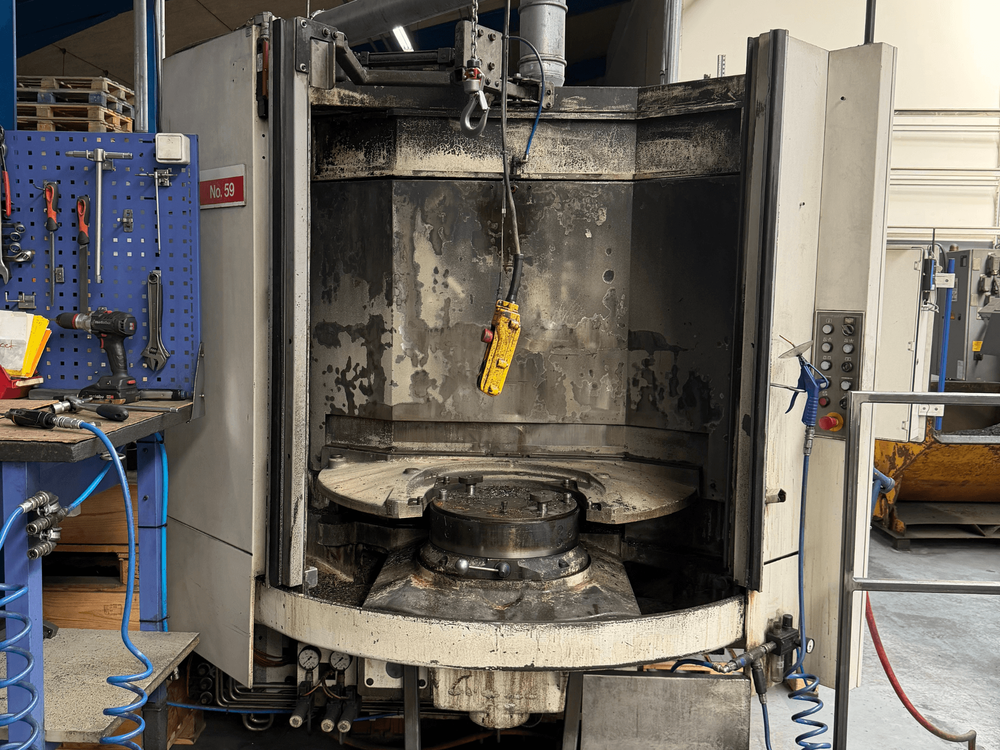 Centro de maquinação horizontal HELLER MC 16, vista frontal, revelando uma mesa de trabalho vazia e um painel de controlo, em ambiente de oficina.