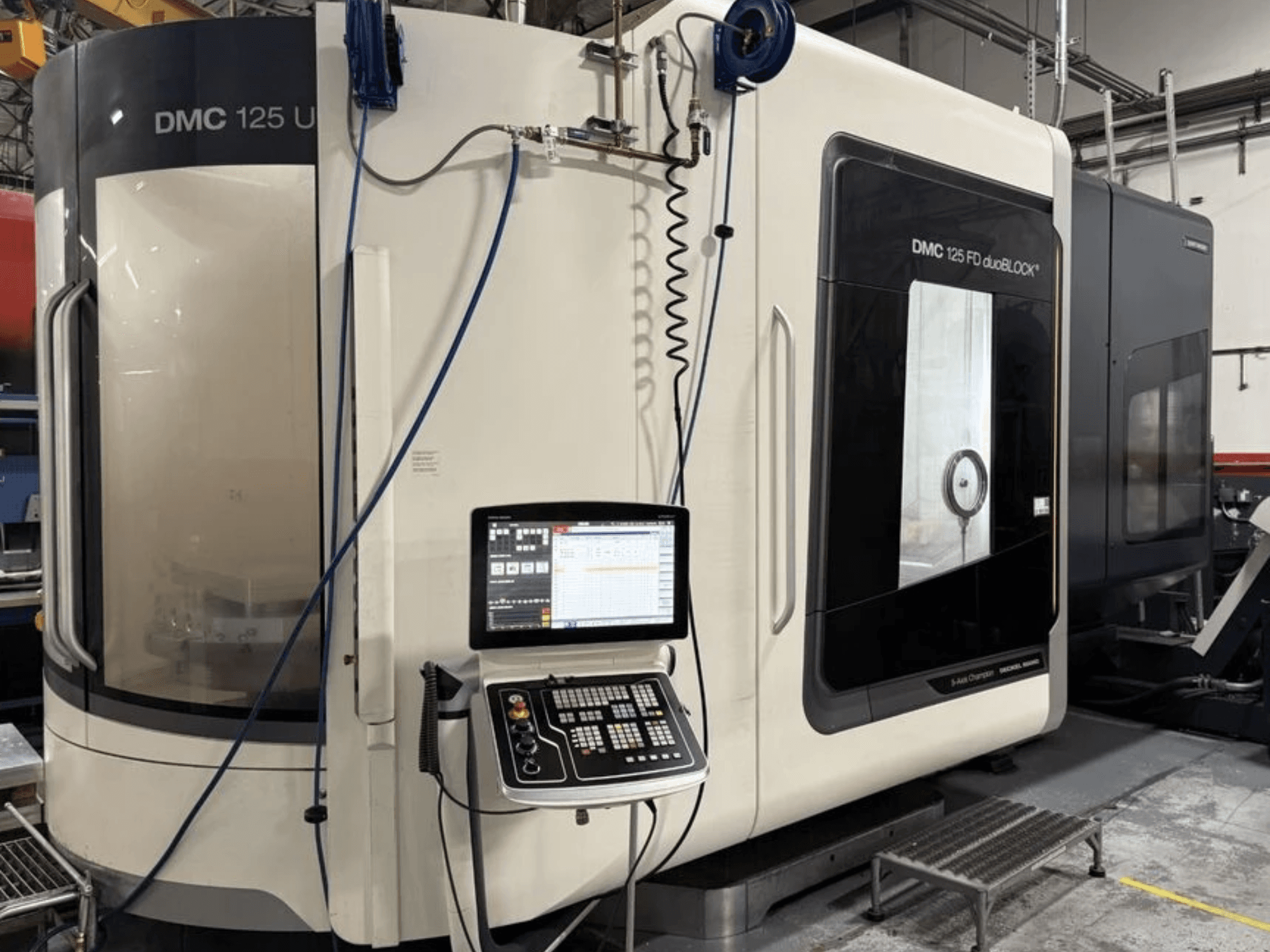 Centro de maquinagem universal DMG MORI DMC 125 U duoBLOCK, vista frontal com painel de controlo e superfícies refletoras.
