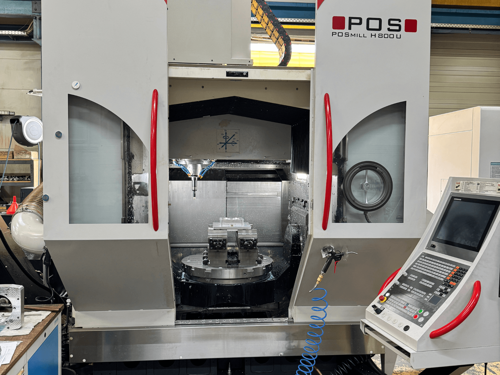 Centro de maquinagem vertical POSmill H 800 U, vista frontal que mostra os componentes internos, o sistema de refrigeração e o painel de controlo.