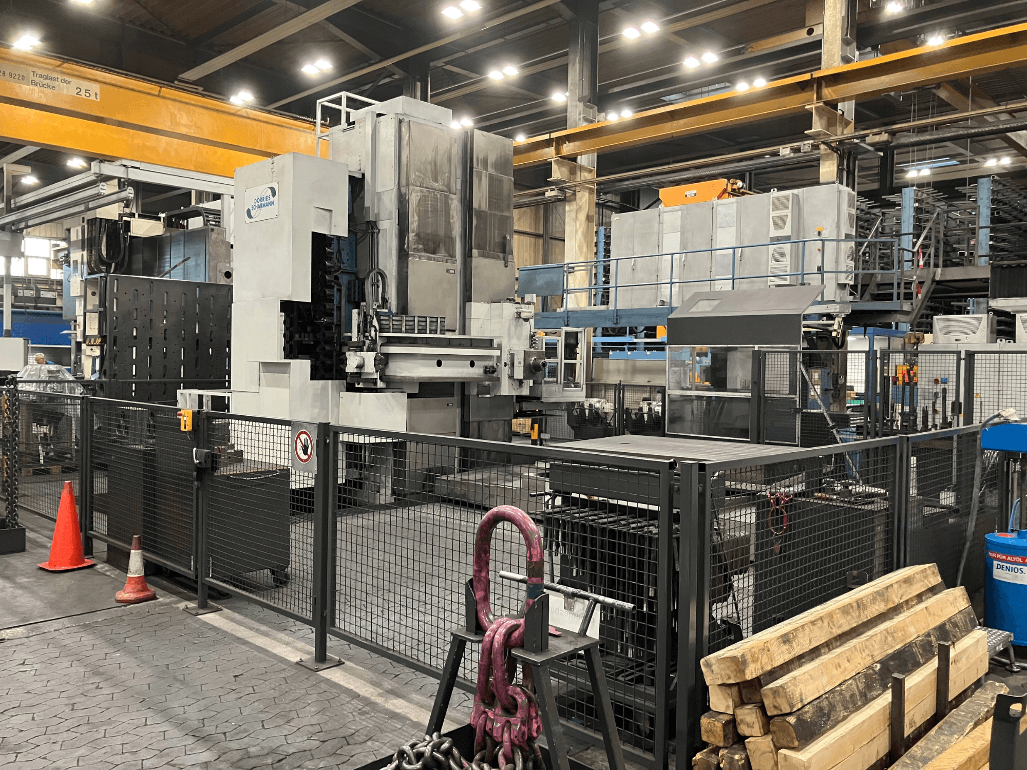 Máquina de perfuração DÖRRIES SCHARMANN Heavycut 1.2 TDV4 num ambiente fabril, vista lateral com barreiras de segurança e ferramentas nas proximidades.