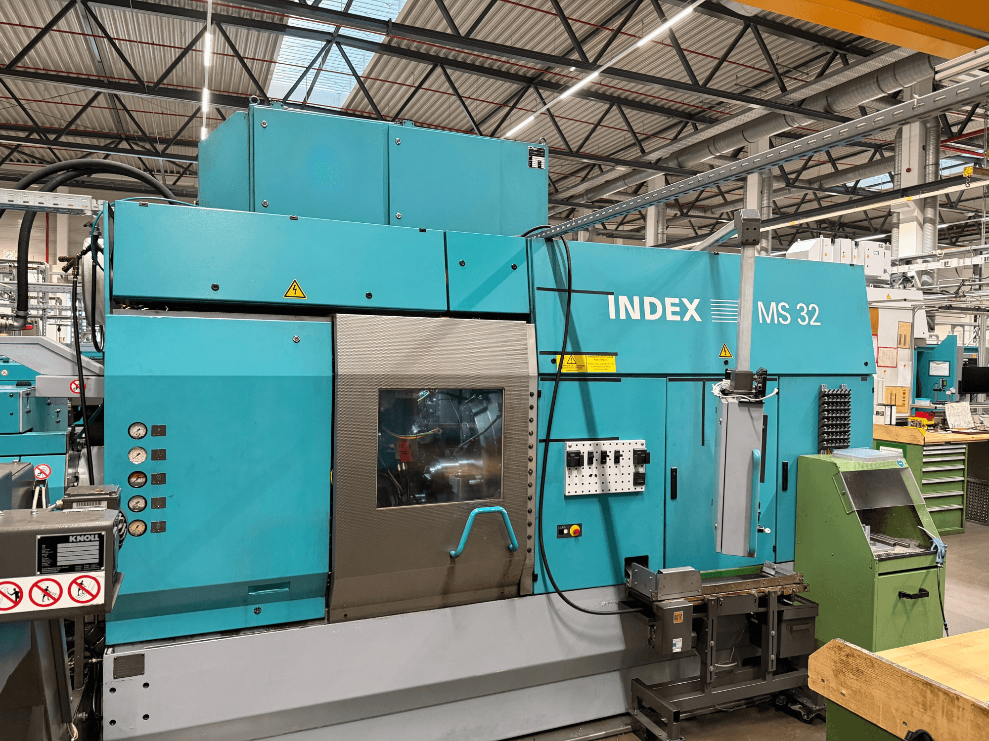 Torno multifuso Index MS32-P, vista frontal com painel de controlo e sistema de refrigeração. Ideal para usinagem de precisão.