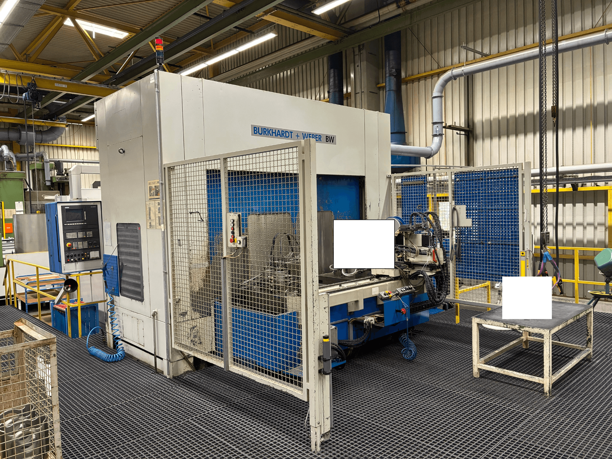 Centro de maquinação Burkhardt + Weber BW, vista frontal, com painel de controlo e caixa de segurança, localizado em ambiente industrial.