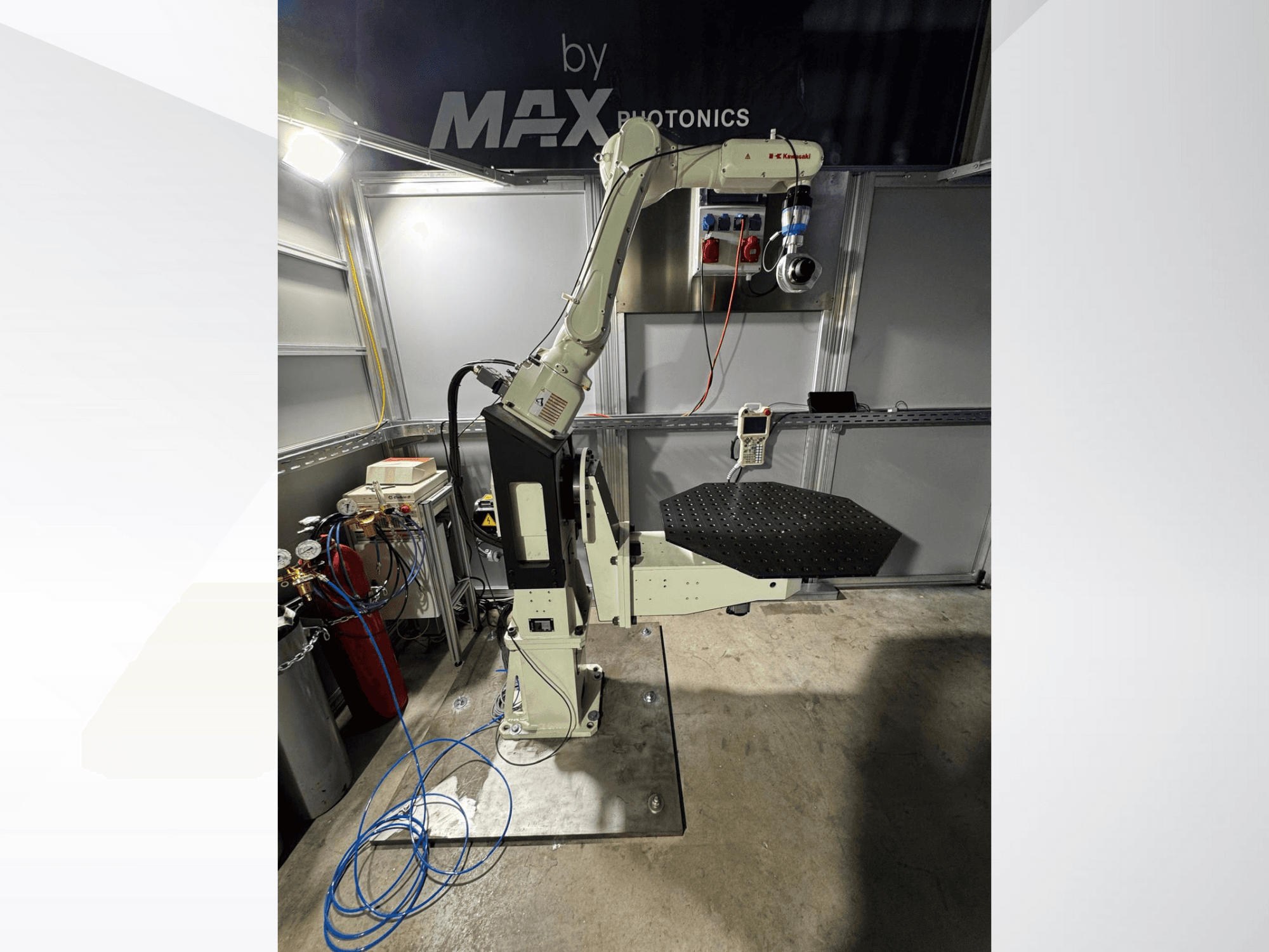 Aparelho de braço robótico Max Photonics, vista frontal, com uma plataforma perfurada preta e um painel de controlo com medidores e cabos.