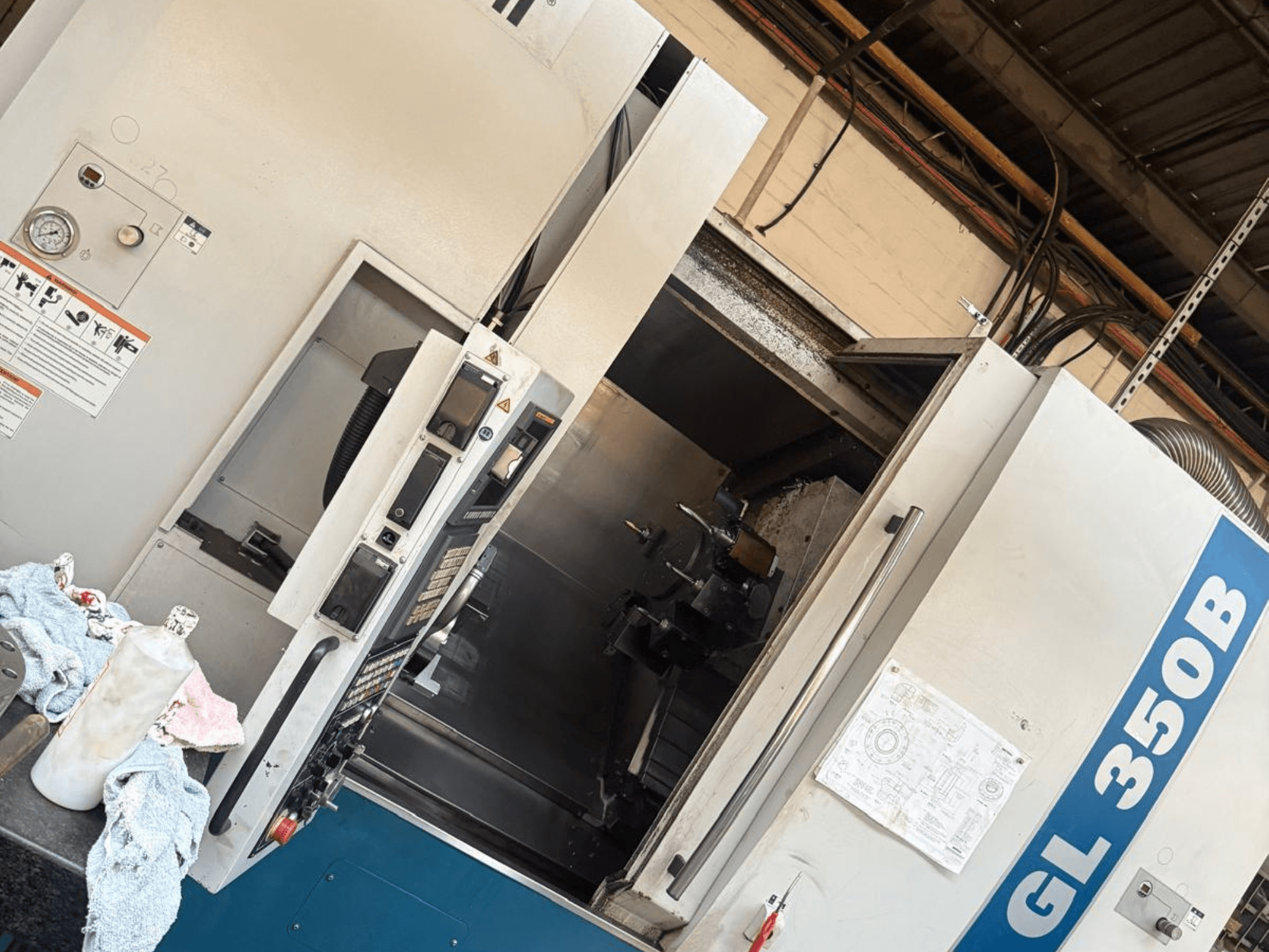 Torneiro horizontal Romi GL 350B, vista frontal, com painel de controlo e porta aberta que revela o interior.