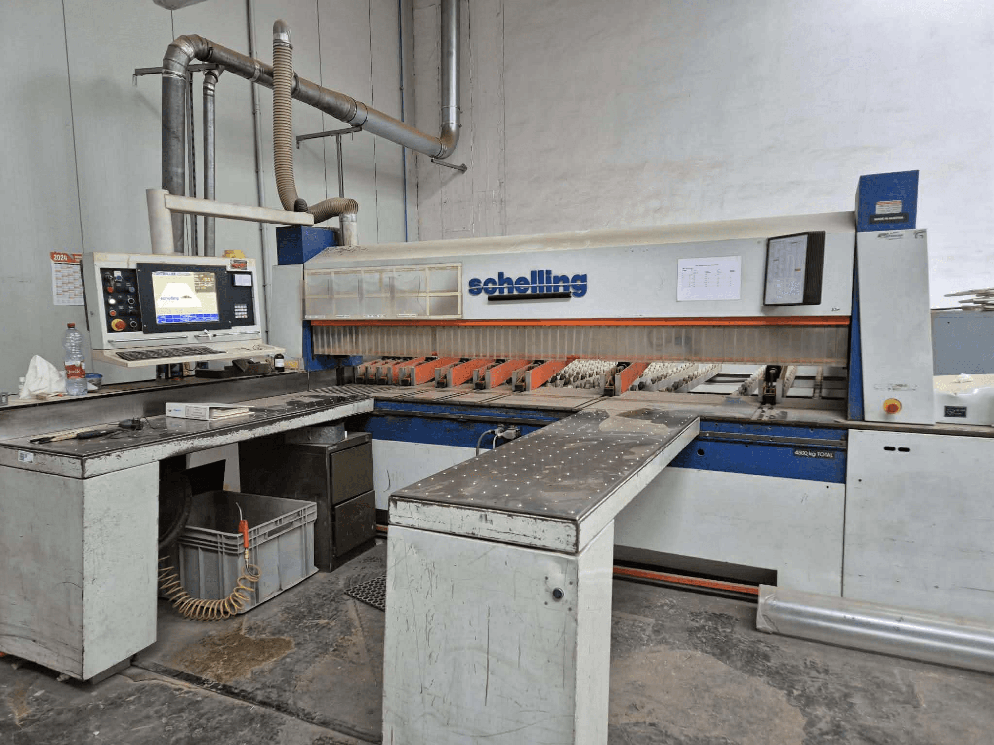 Máquina de corte Schaublin em vista lateral, com uma interface de computador, lâminas afiadas e uma superfície de trabalho metálica robusta.