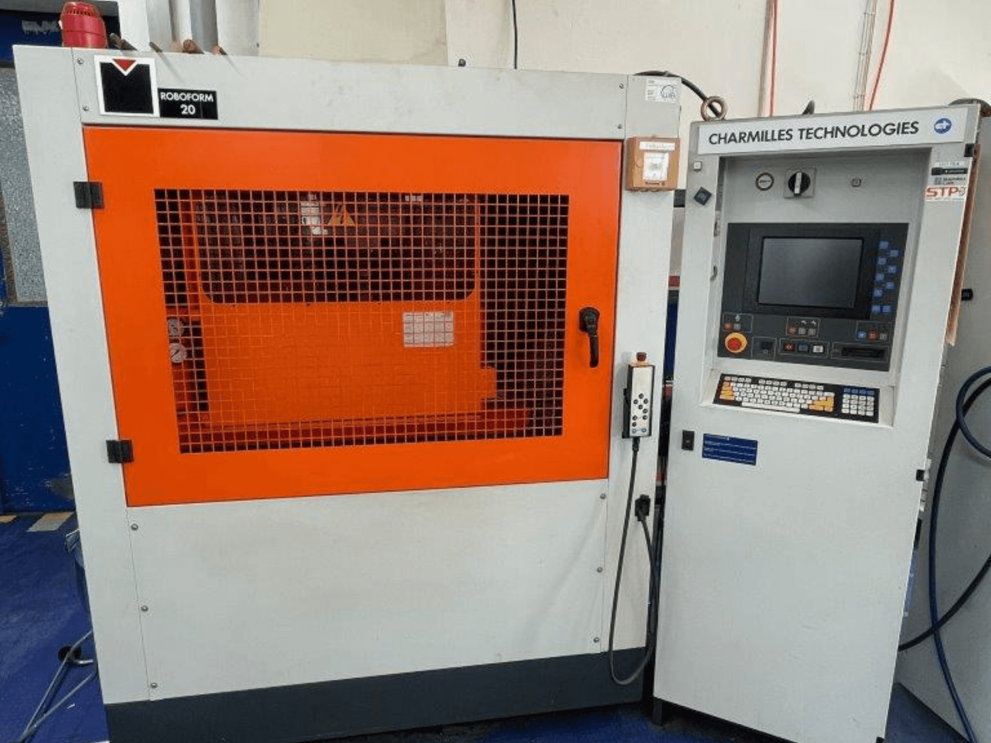 Máquina EDM para confeção de matrizes AgieCharmilles Robofrom 20, vista frontal com painel de controlo e grelha de proteção laranja.