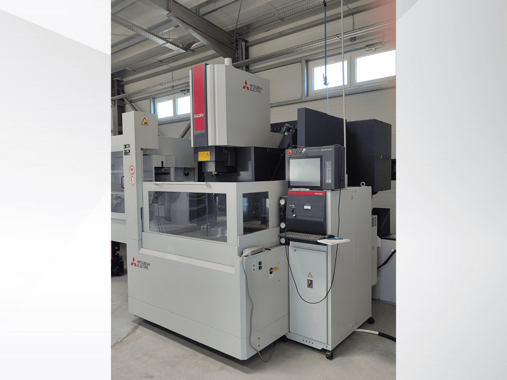 Máquina EDM de corte a fio Mitsubishi Electric EA32V em vista lateral, com painel de controlo e área de trabalho visível através de vidro.