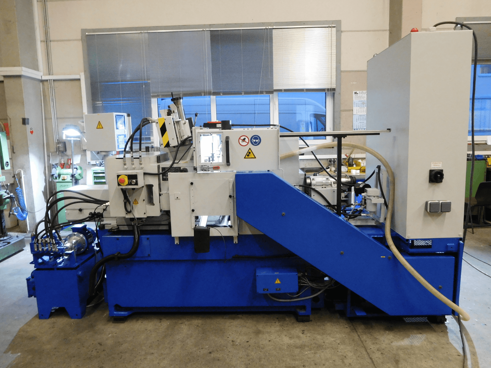 Máquina de retificação sem centros Schaudt Mikrosa SASL 125, vista lateral, com base azul e painel de controlo, apresentando caraterísticas operacionais.