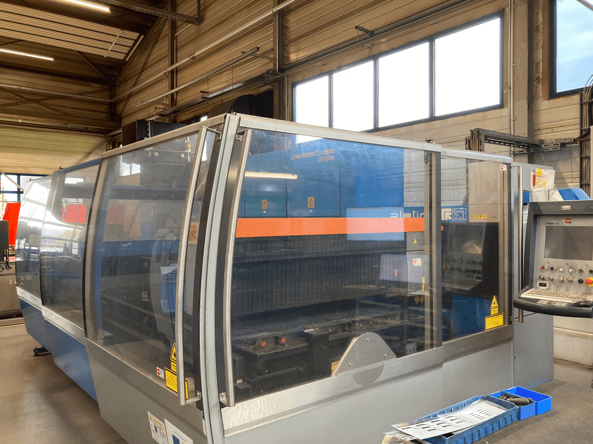 Máquina de corte a laser Prima Industrie Platino 1530 CO2, vista frontal, com painel de controlo e caraterísticas de segurança visíveis.