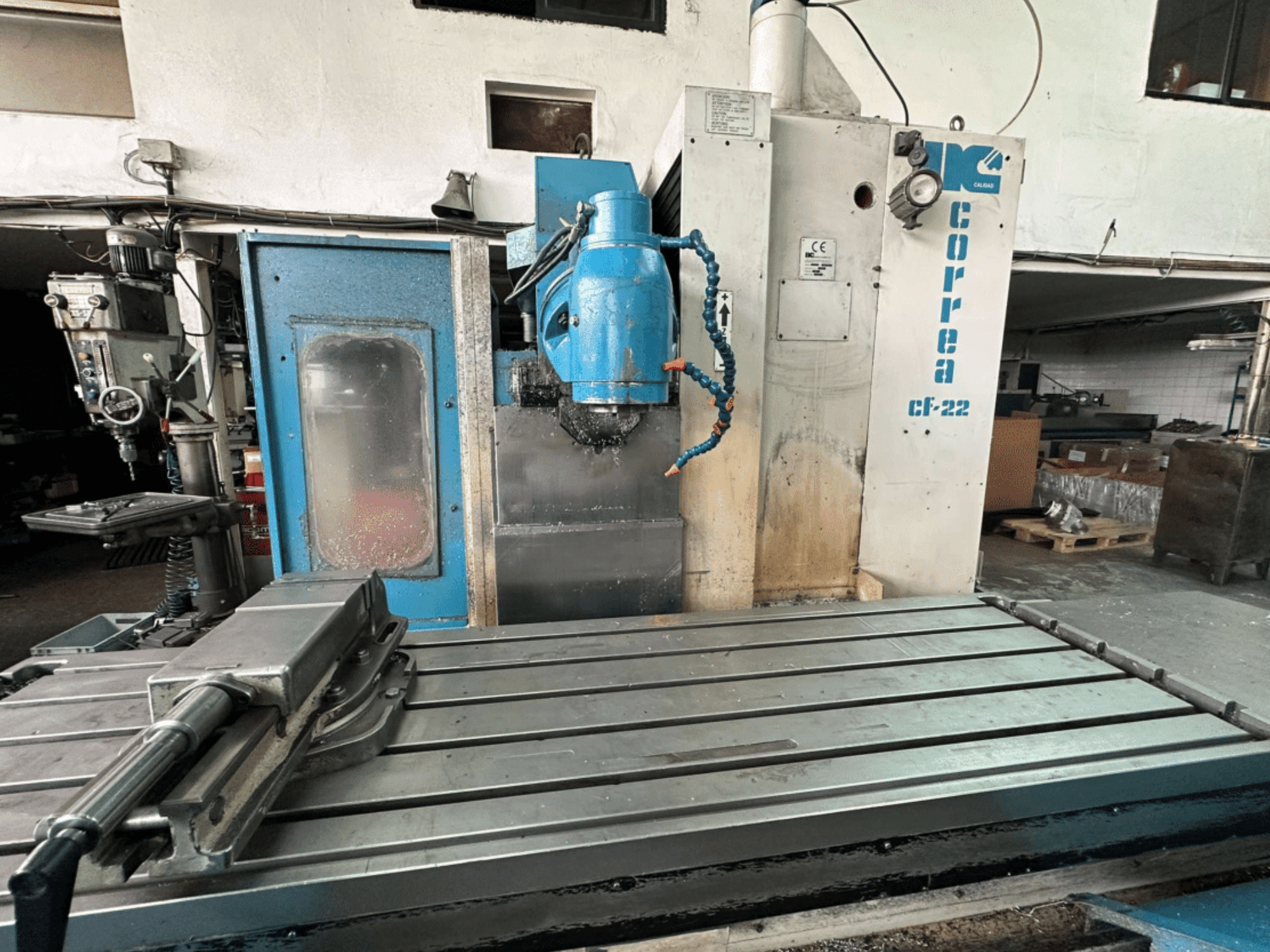 Fresadora Correa CF-22 apresentada em vista frontal, com design azul e prateado, com mesa deslizante e cabeça de corte.