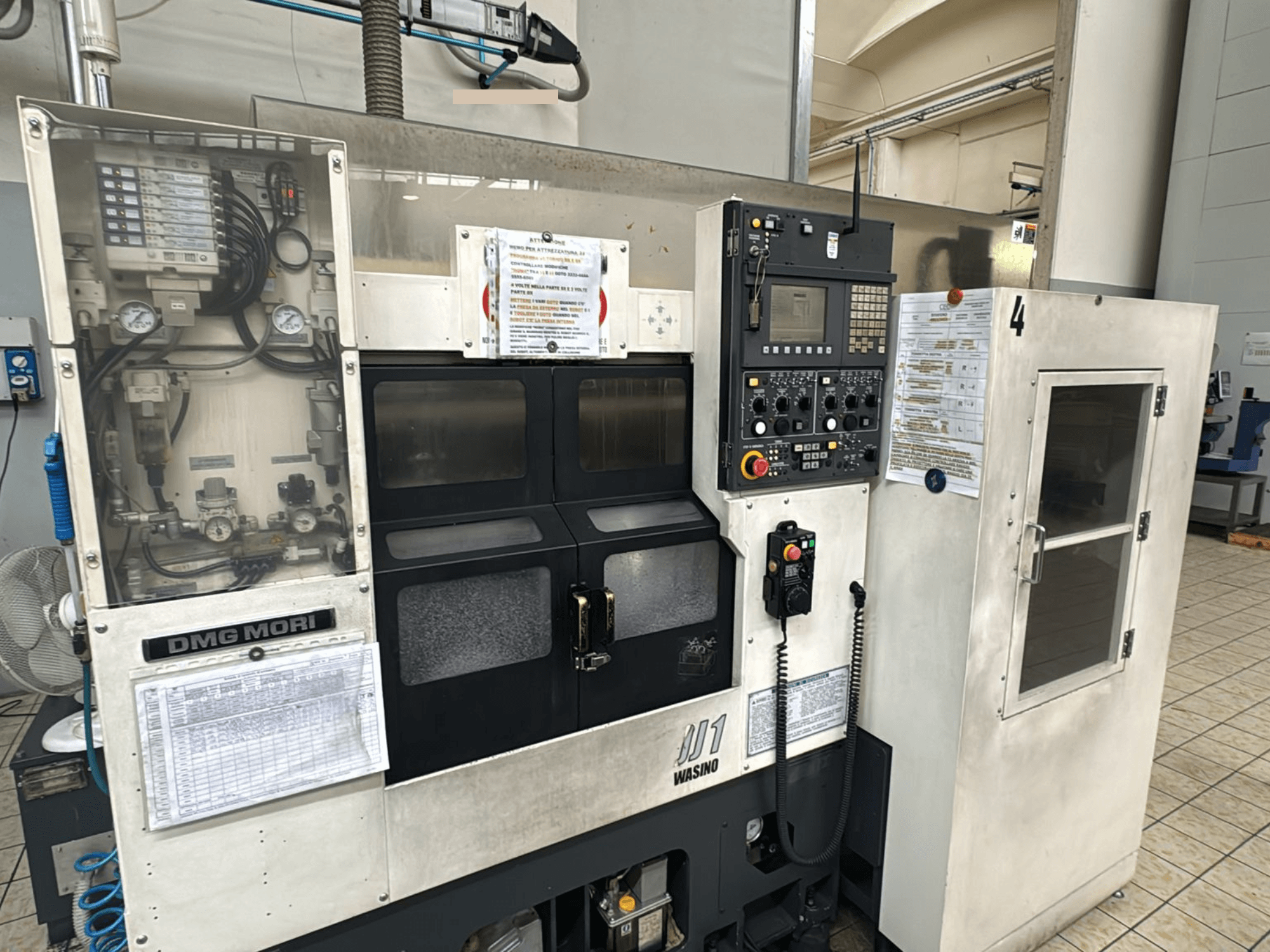 Máquina CNC DMG Mori JD1, vista frontal, com painel de controlo e detalhes de operação exibidos, ambiente industrial.