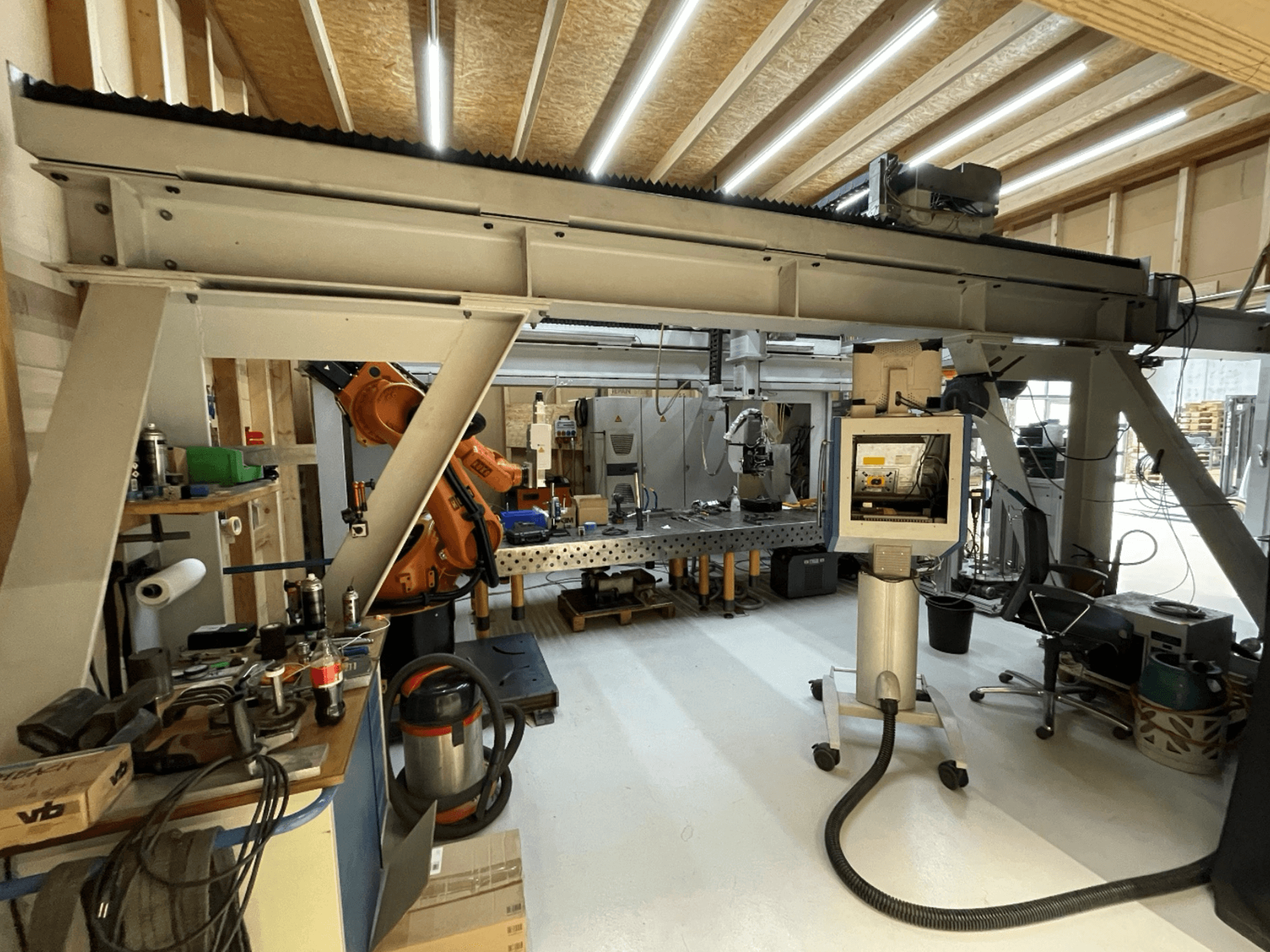 Máquina-ferramenta Stiefelmayer Laserhärtenanlage, vista frontal, mostrando o braço robótico e o painel de controlo numa oficina.