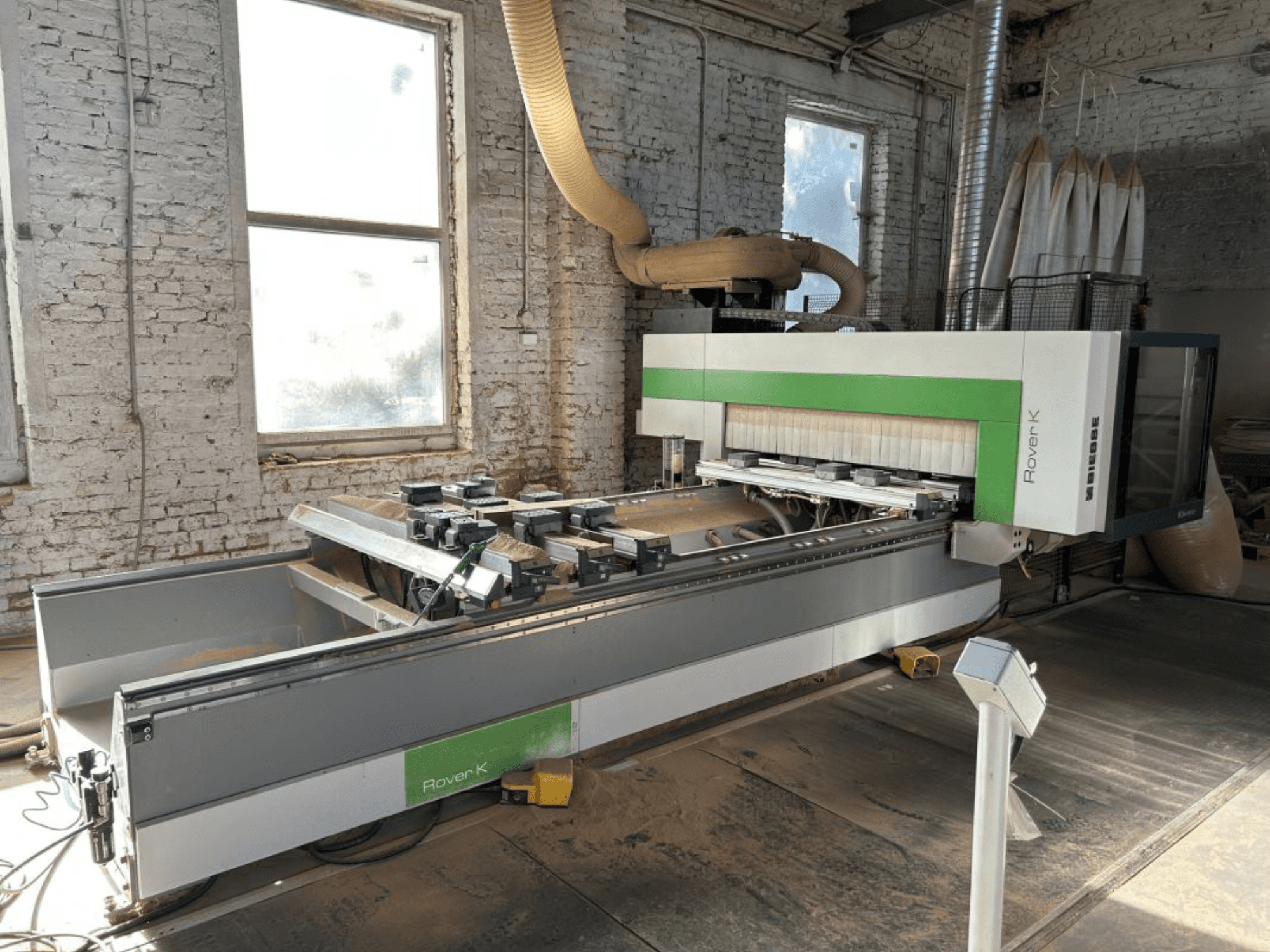 Centro de usinagem CNC BIESSE Rover K 1532 G numa oficina, visto de frente, exibindo as suas ferramentas de corte e a superfície de trabalho.