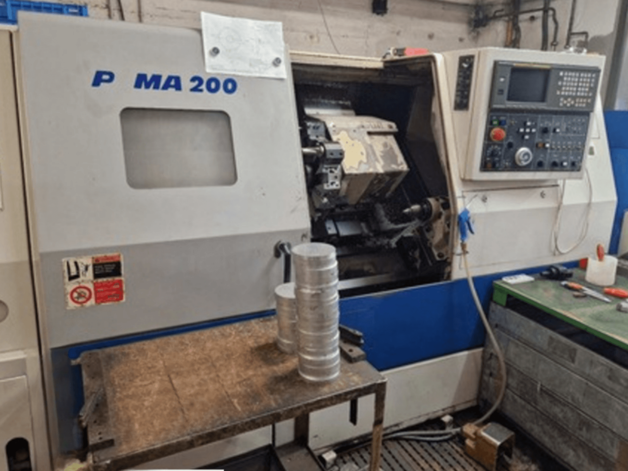 DAEWOO EcoTurn 200 máquina de torneamento horizontal, vista frontal, com peças de alumínio numa mesa, painel de controlo visível.