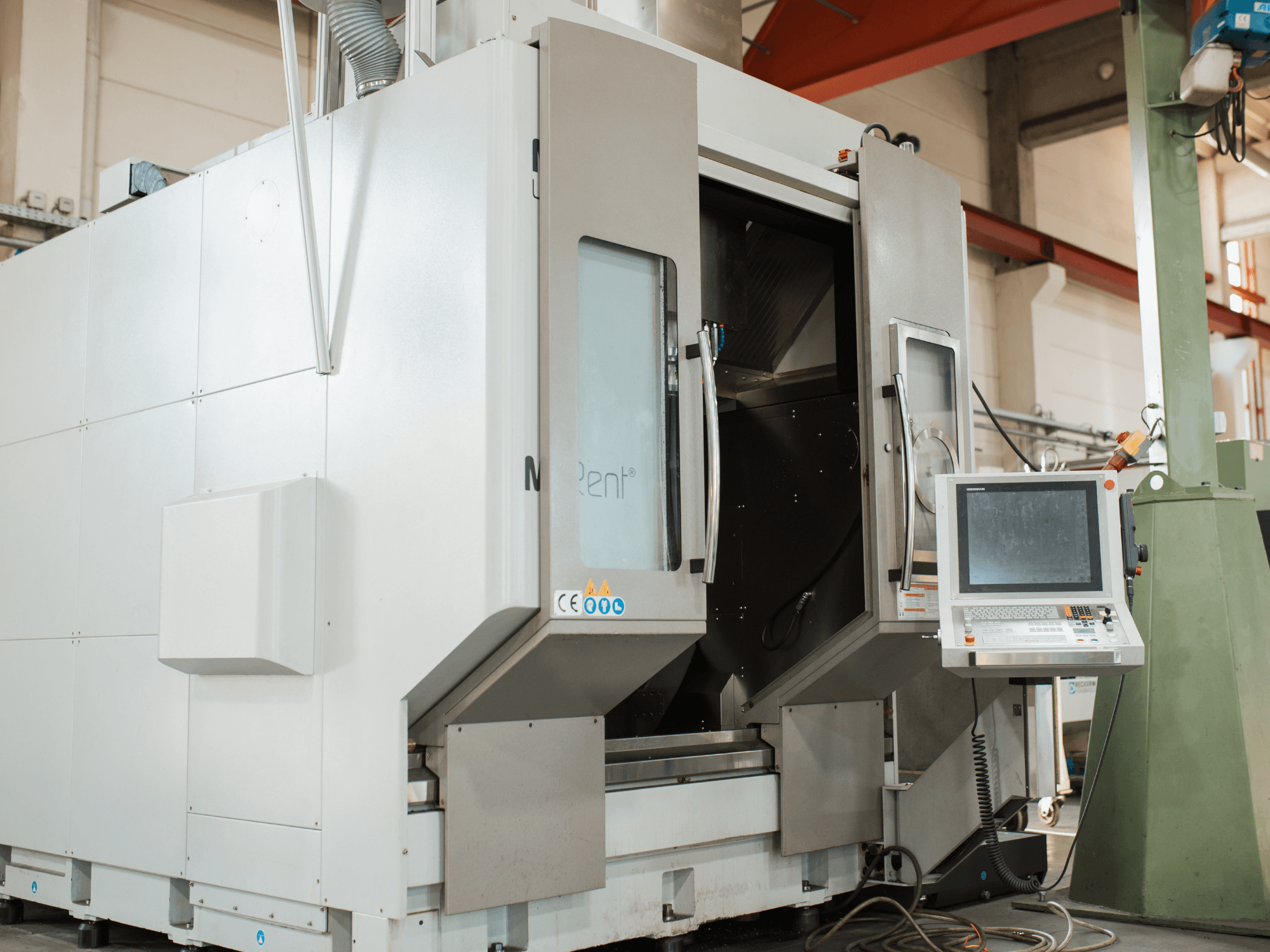 A fresadora CNC N Rent®, vista de frente, apresenta um painel de controlo com ecrã, portas abertas e ambiente industrial.