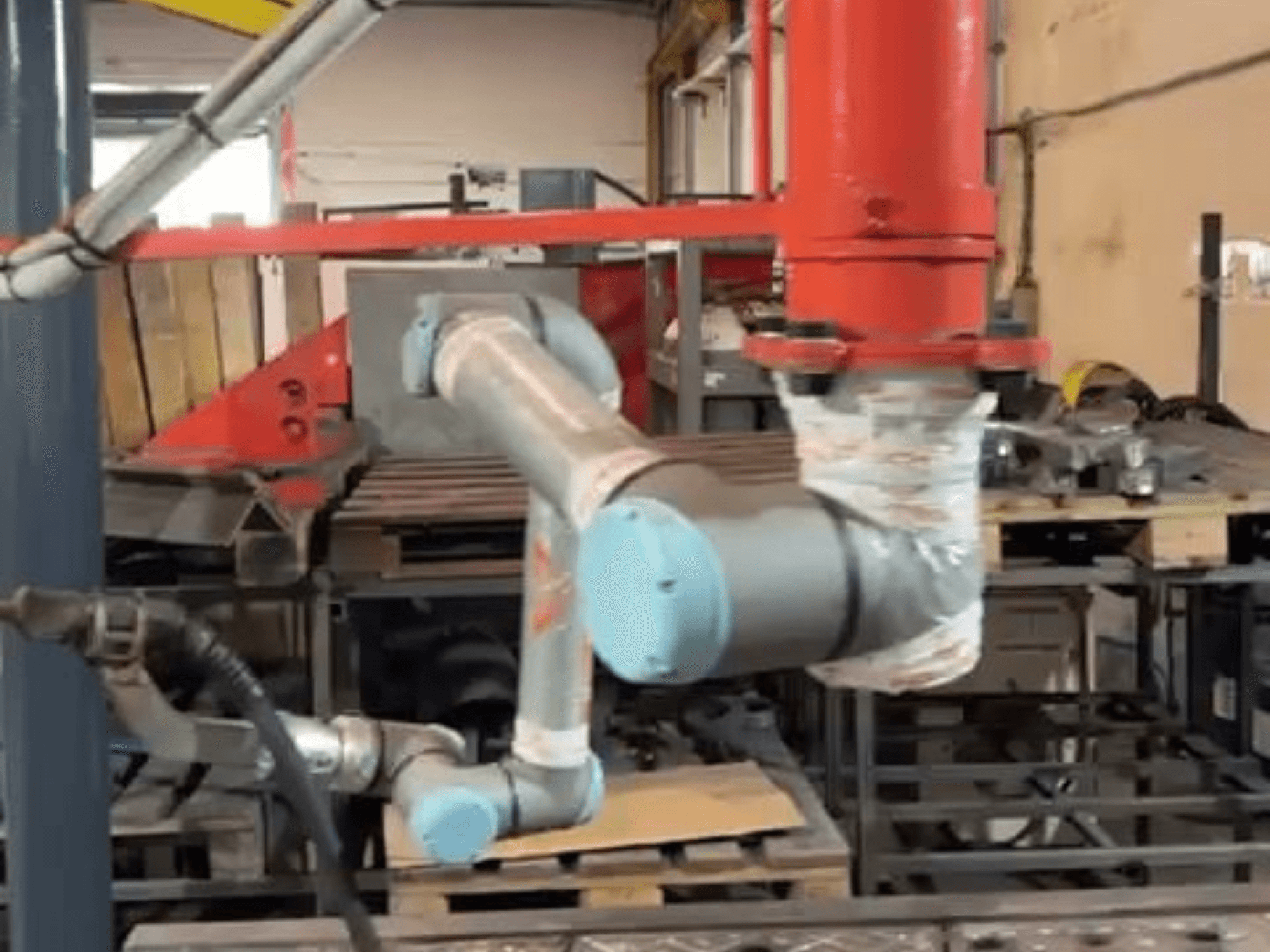 Robô colaborativo UR10e da Universal Robots numa oficina; vista lateral que mostra os movimentos do braço e das articulações junto ao equipamento.