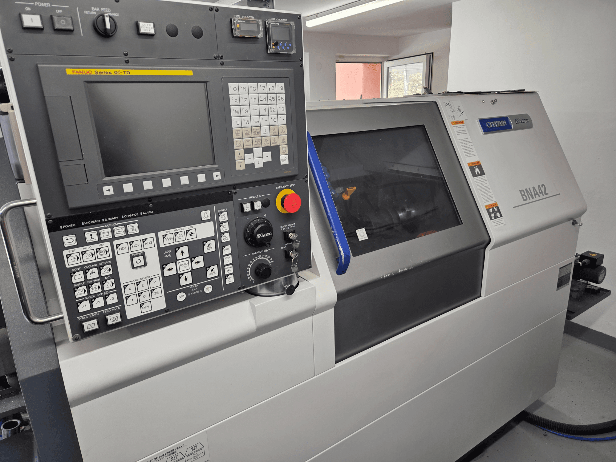 Torno horizontal Miyano BNA42S2, vista frontal que mostra o painel de controlo com a interface e o ecrã da série Oi-TD da FANUC.