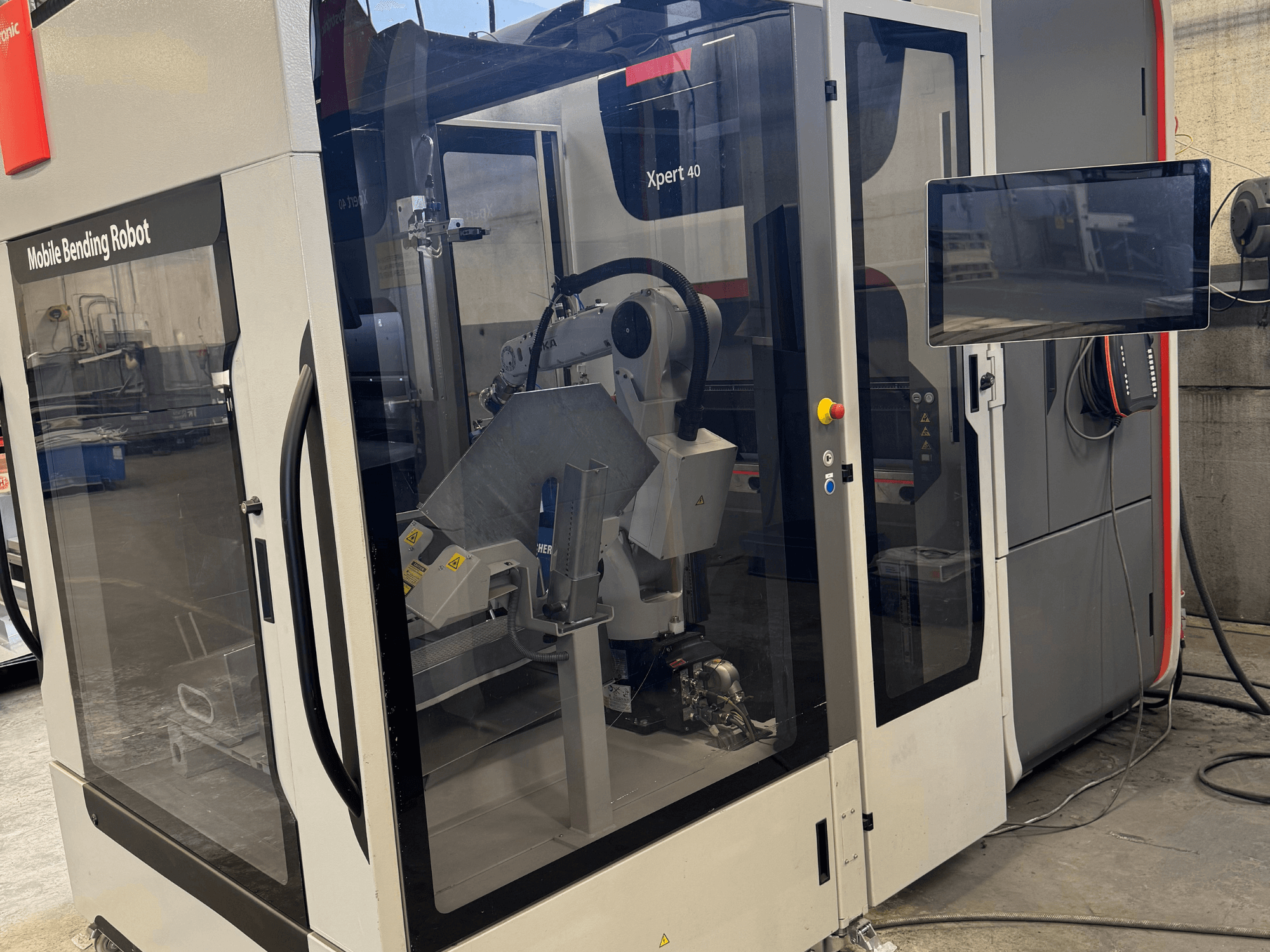 Prensa dobradeira Bystronic Xpert 40/1030 com robô de dobra móvel, vista frontal do painel de comando e dos componentes robóticos.