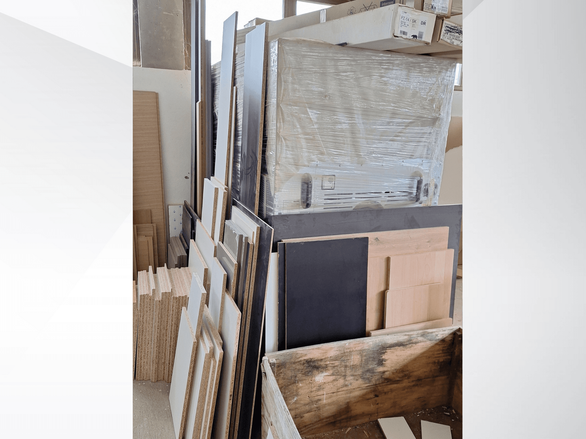Painéis e placas de contraplacado variados empilhados, mostrando vários acabamentos; vista frontal de materiais num ambiente de oficina.