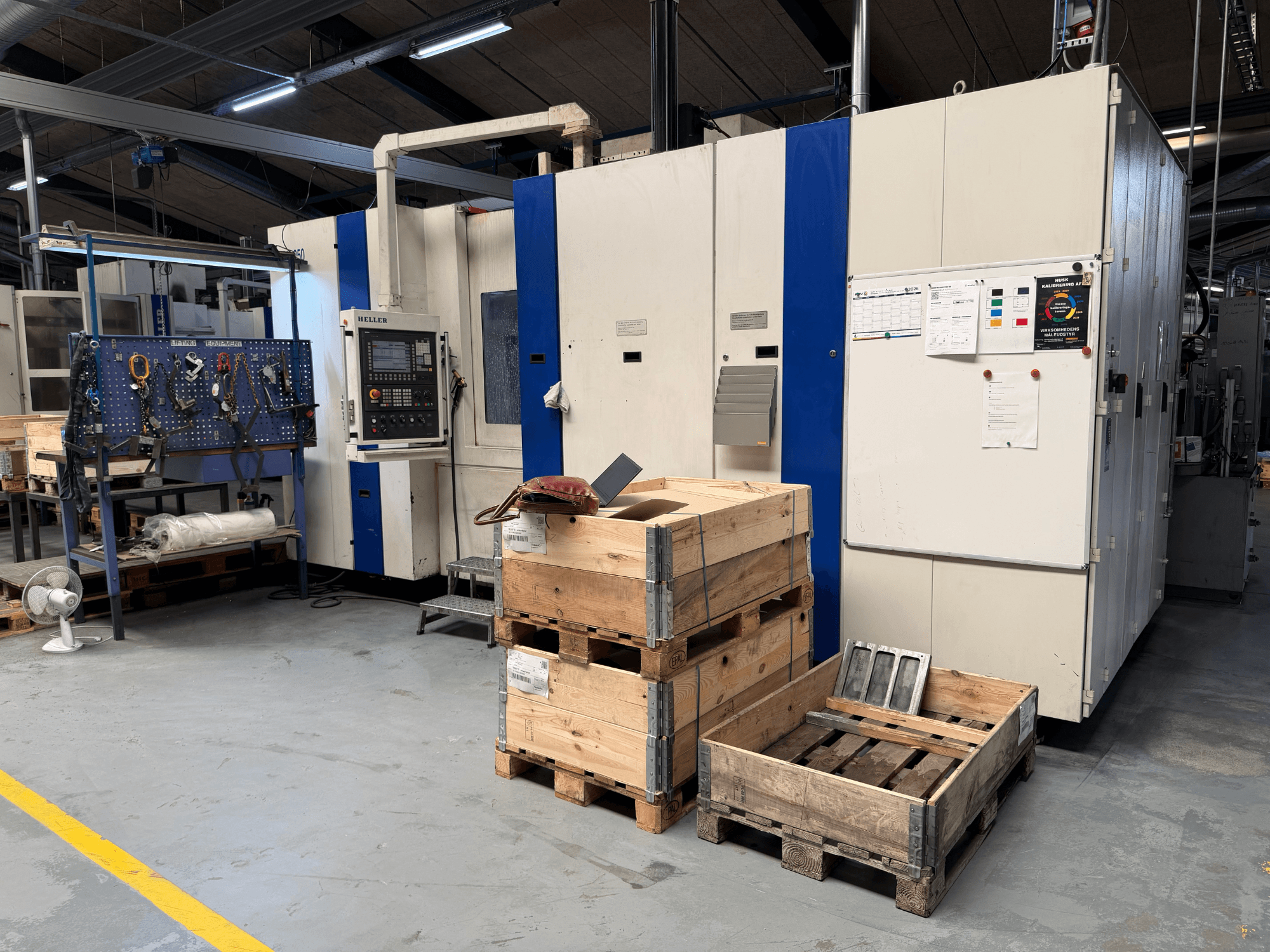 CENTRO DE MÁQUINAS HORIZONTAL HELLER MCH 250 em oficina, vista lateral com paletes de madeira e porta-ferramentas visíveis.