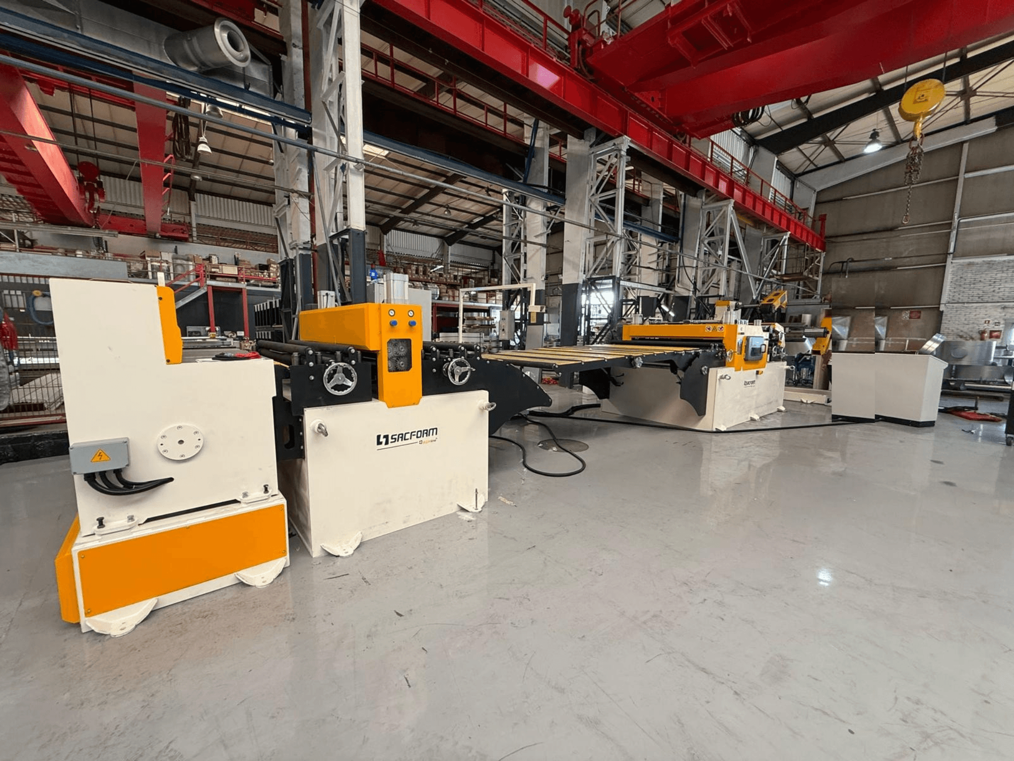 Vista frontal da máquina para chapas metálicas SACFORM CRL1503-6, com um design em amarelo e branco, rodas e comandos operacionais.