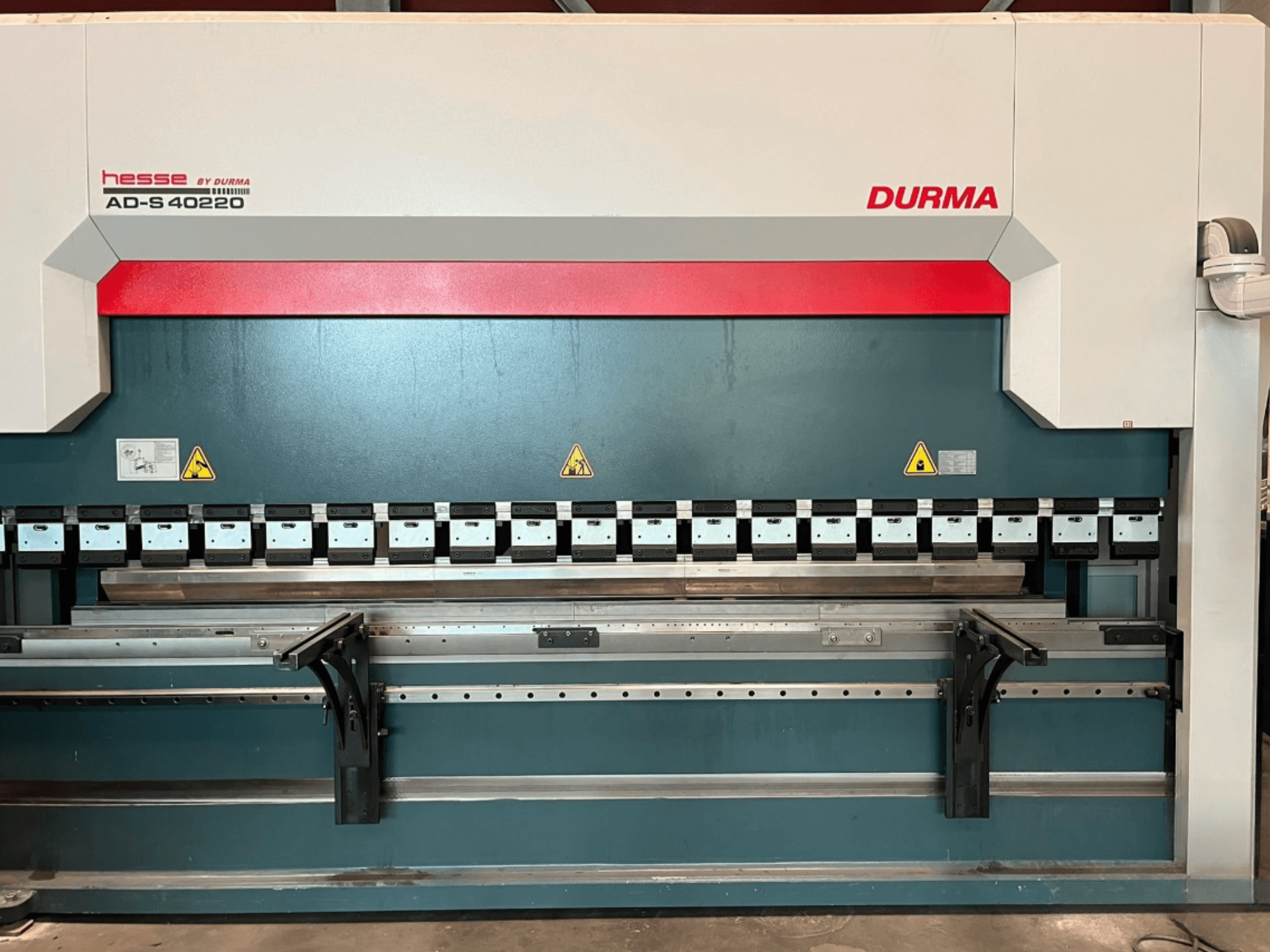 Prensa-dobra Durma AD-S 40220 vista de frente, com várias ferramentas de dobragem e etiquetas de segurança.