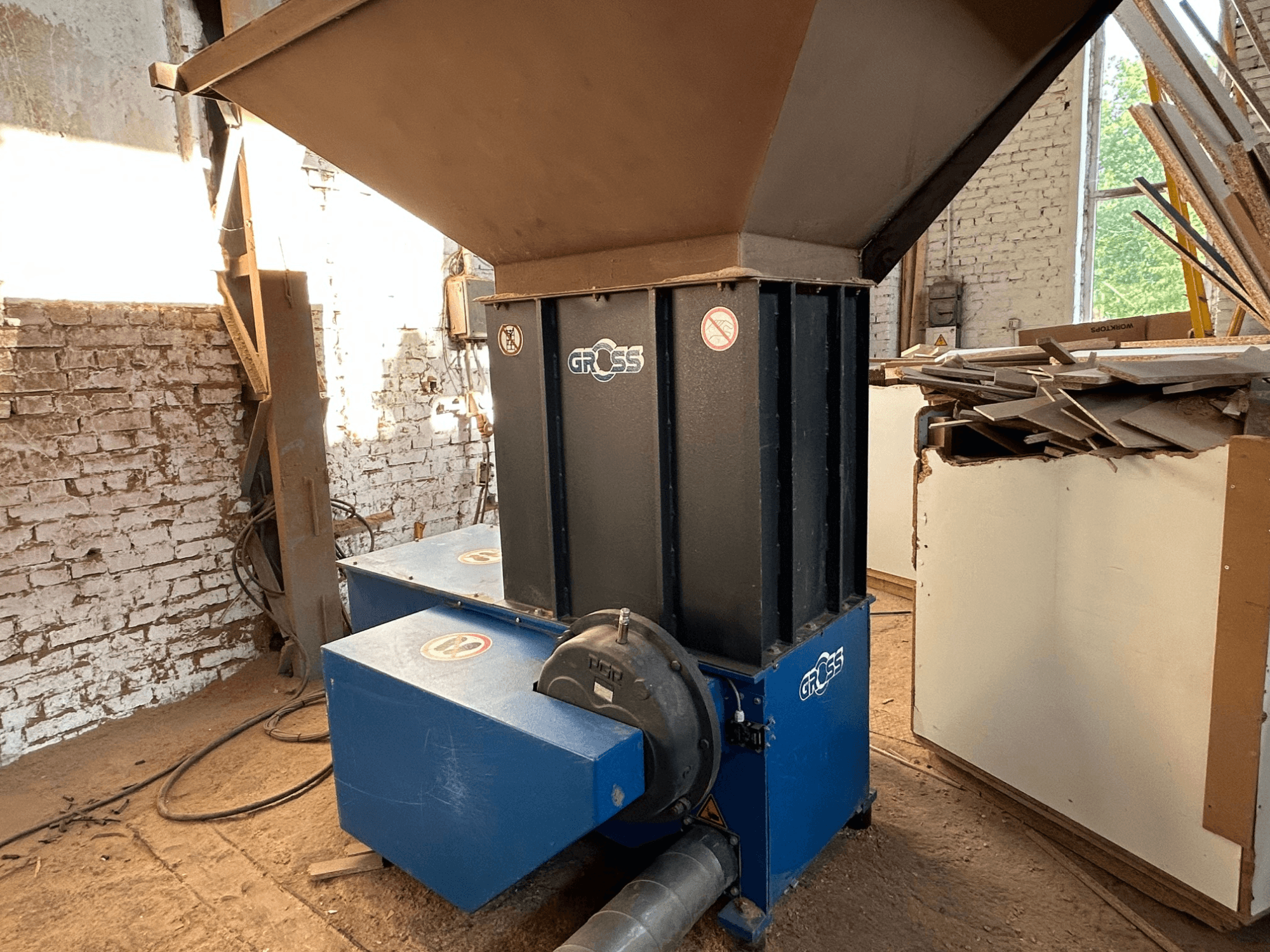 Máquina de processamento de madeira GROSS GAZ62 numa oficina, com uma tremonha vertical e duas unidades de base azuis, vista de lado.