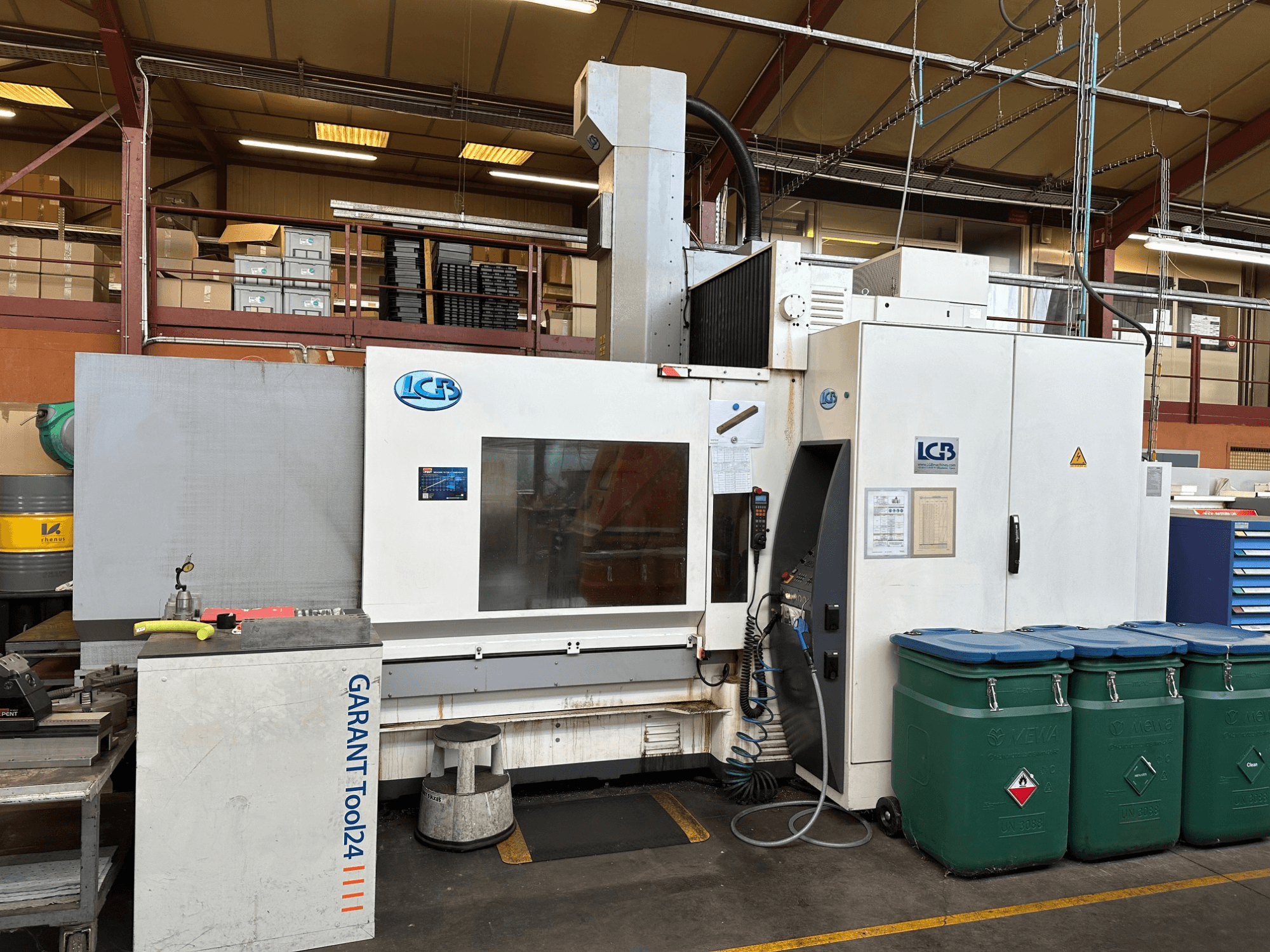 Máquina CNC LGB vista de frente, com posto de trabalho GARANT Tool24 e caixotes de lixo verdes ao lado.