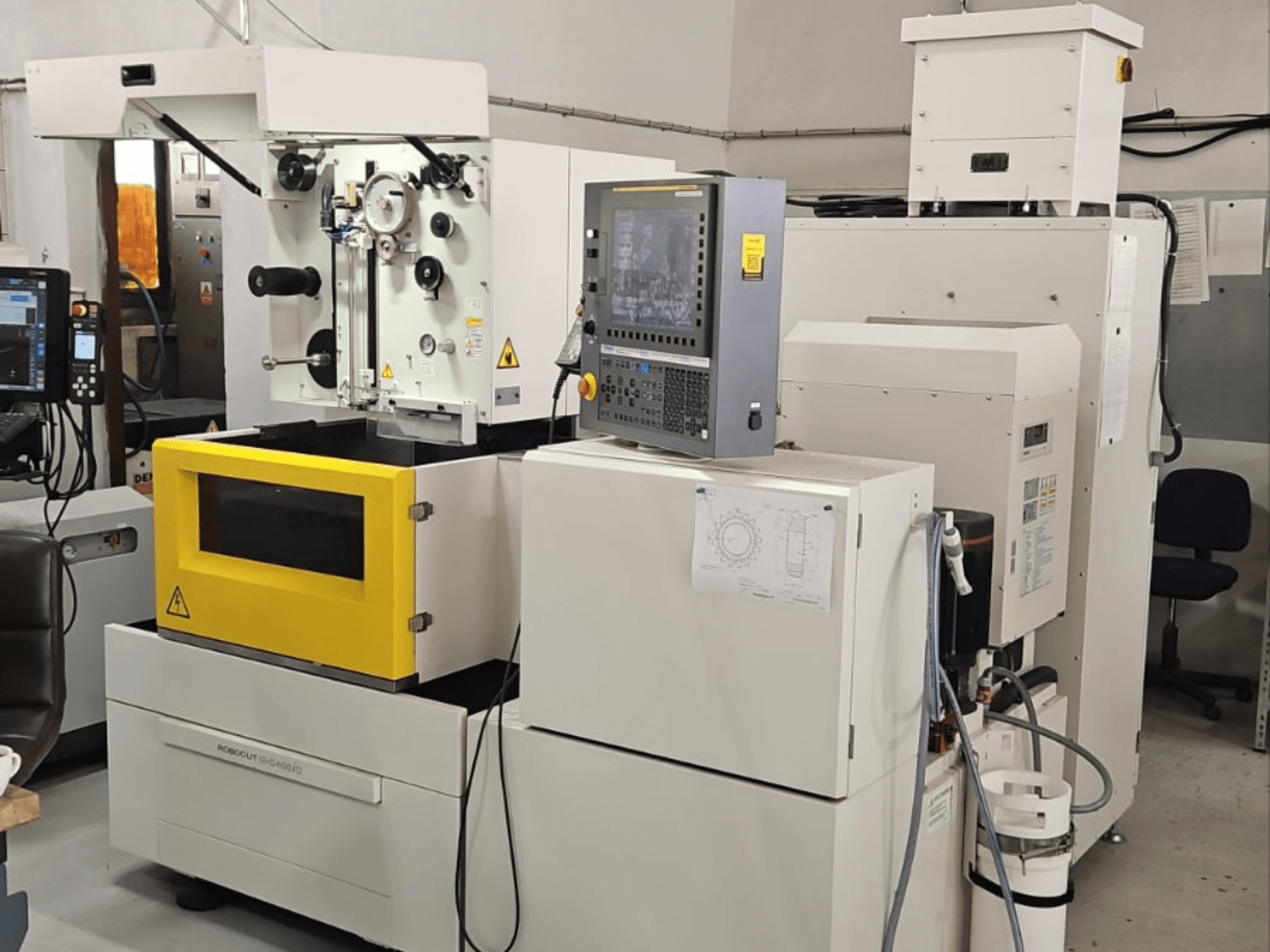 Máquina de eletroerosão por fio FANUC Robocut alpha C400iC, vista frontal que mostra o painel de controlo e a câmara de trabalho amarela.