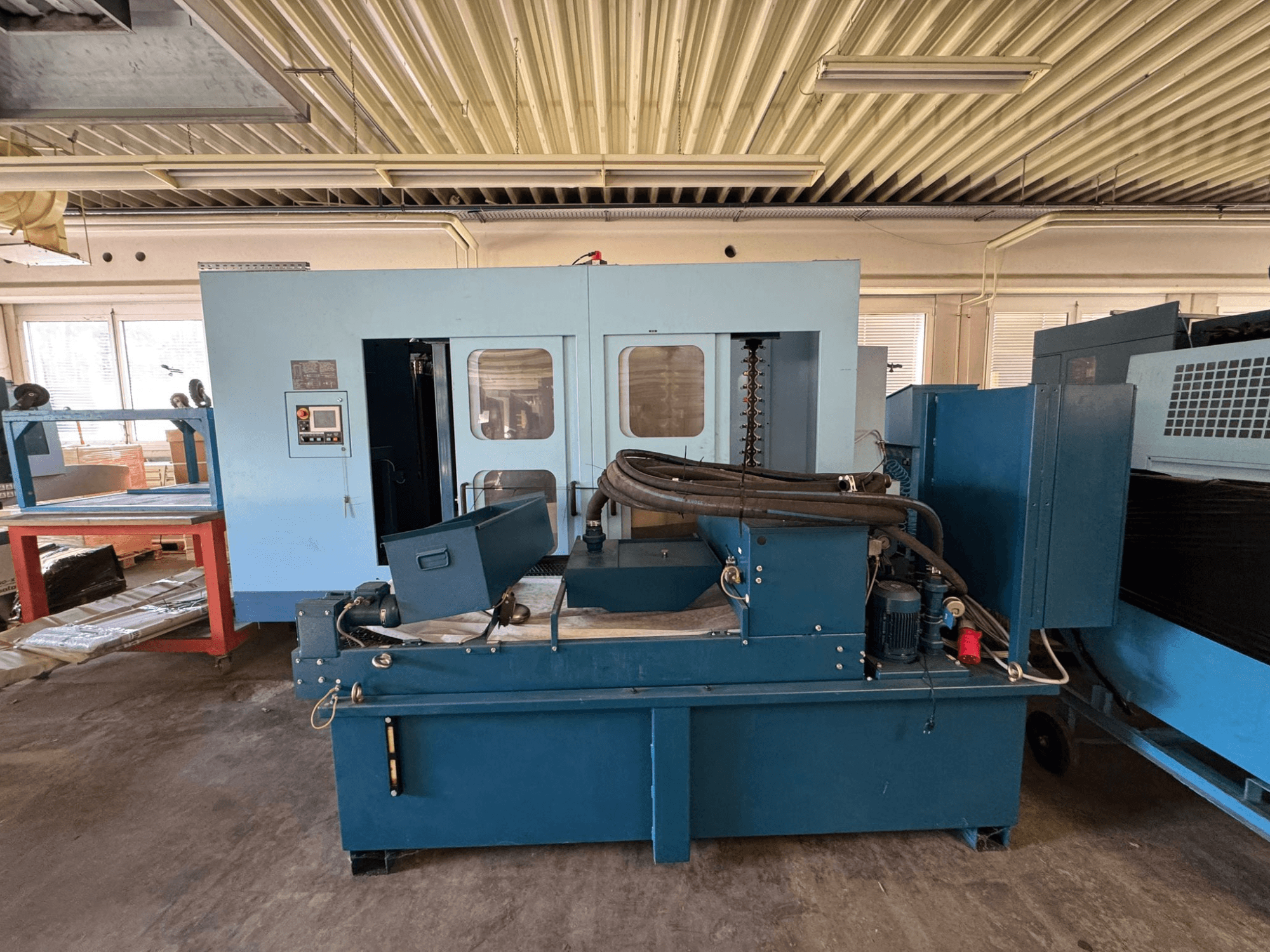 Centro de maquinagem horizontal Matsuura H. Plus 405 em azul, vista frontal, mostrando o painel de controlo e os componentes da máquina.