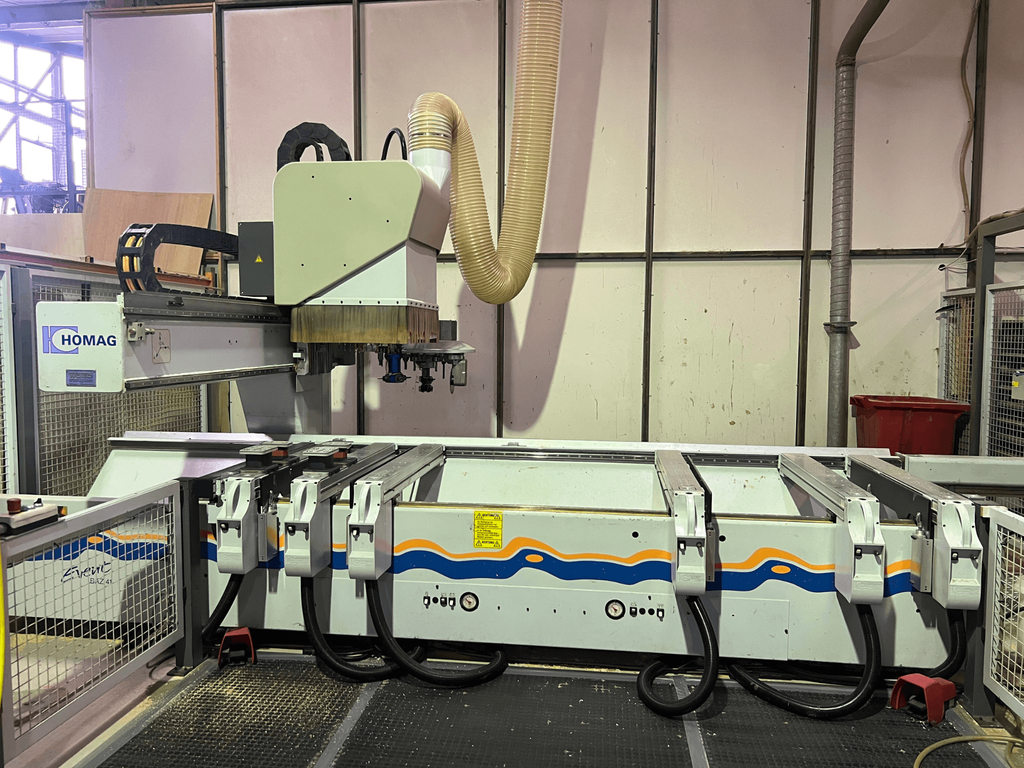 Máquina CNC HOMAG BIZ 4 na oficina; vista frontal mostrando o sistema de extração de poeiras e o painel de controlo com cabos.