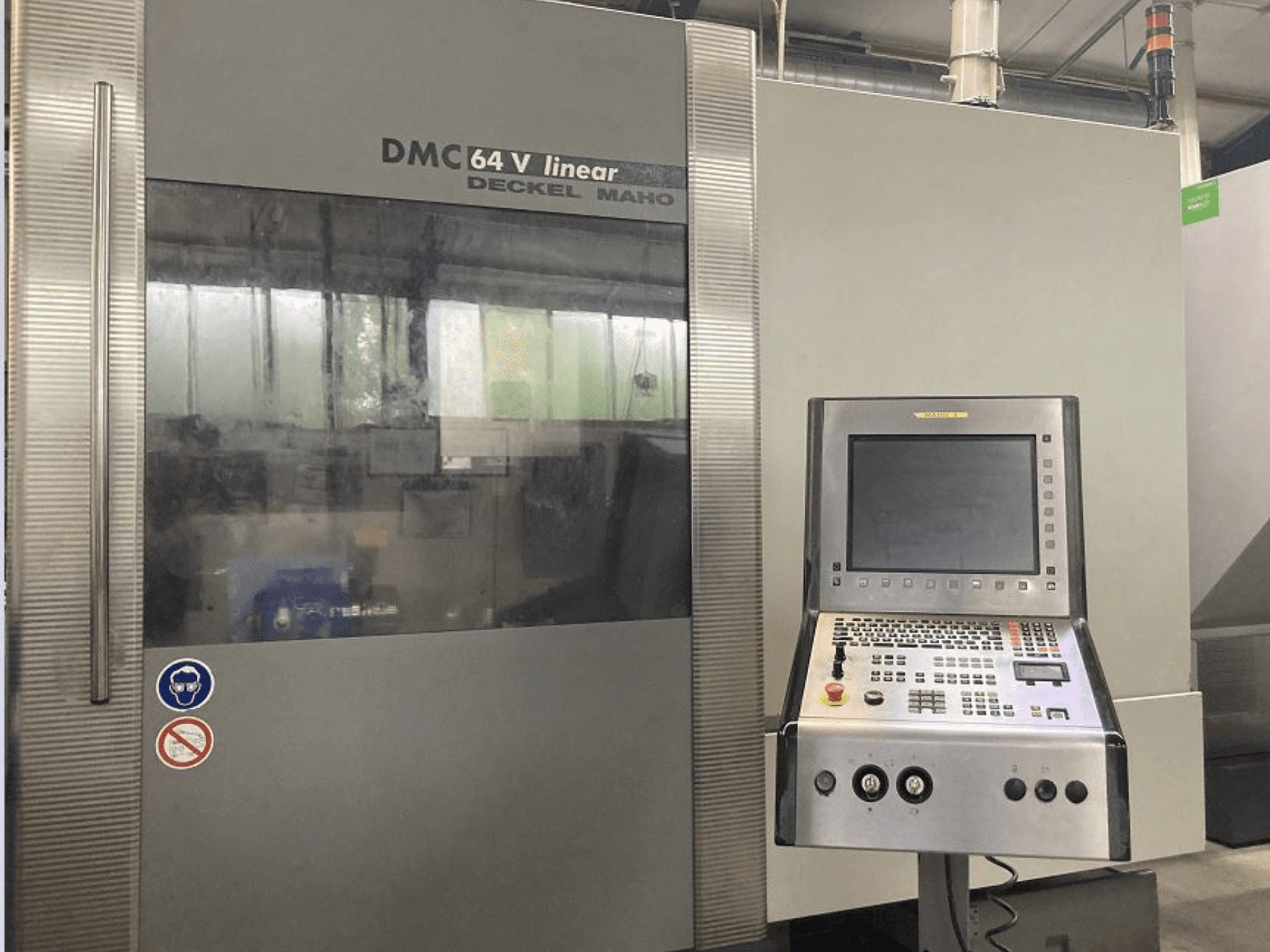 Centro de maquinação vertical linear DMG DECKEL MAHO DMC 64V, vista frontal mostrando o painel de controlo e o visor.